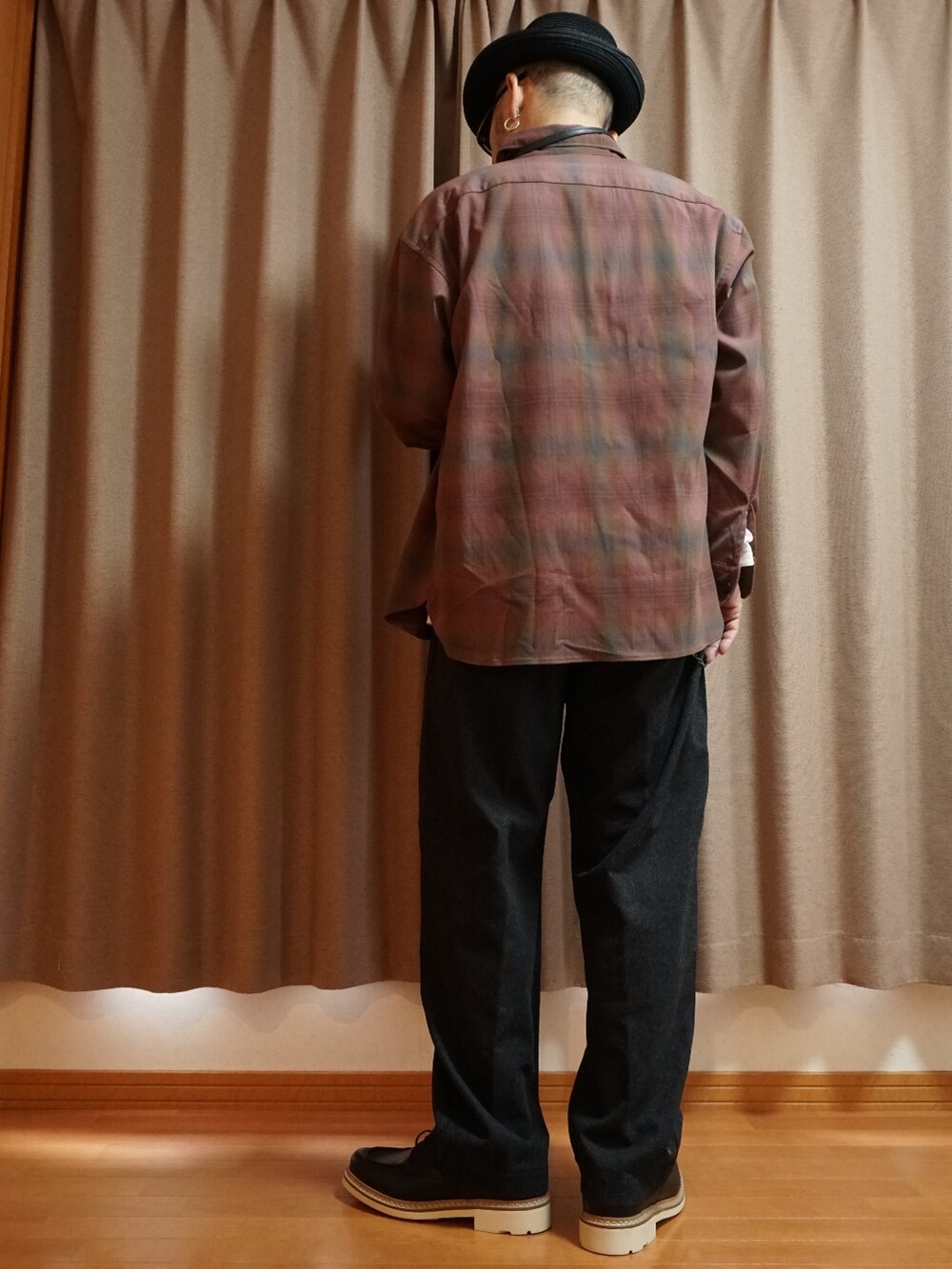 ブラック系のシューズ、グレー系のパンツ、ブラック系のショルダーバッグを着用したメンズの秋コーディネートの3枚目の写真