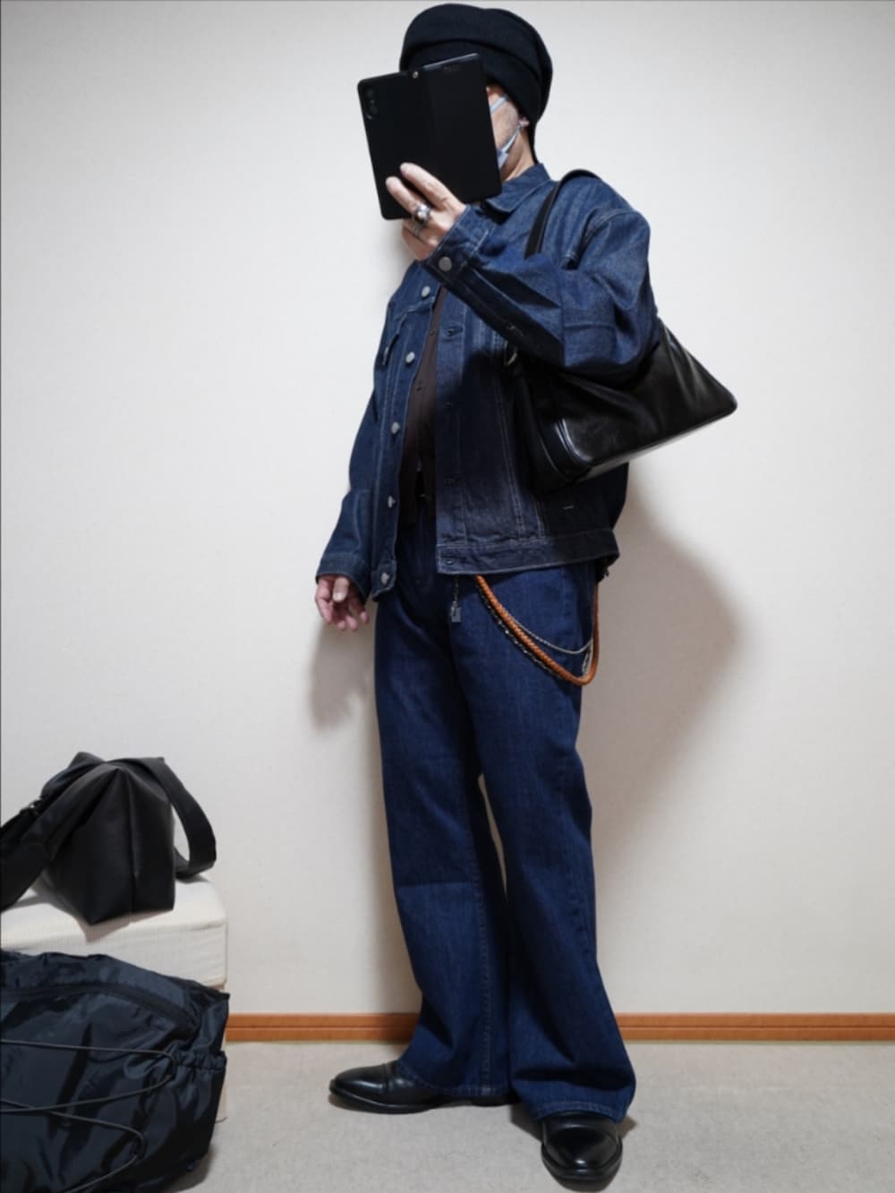 ブラック系のドレスシューズ、ブルー系のデニムパンツ、ブラウン系のカーディガン/ボレロを着用したメンズの春コーディネートの2枚目の写真