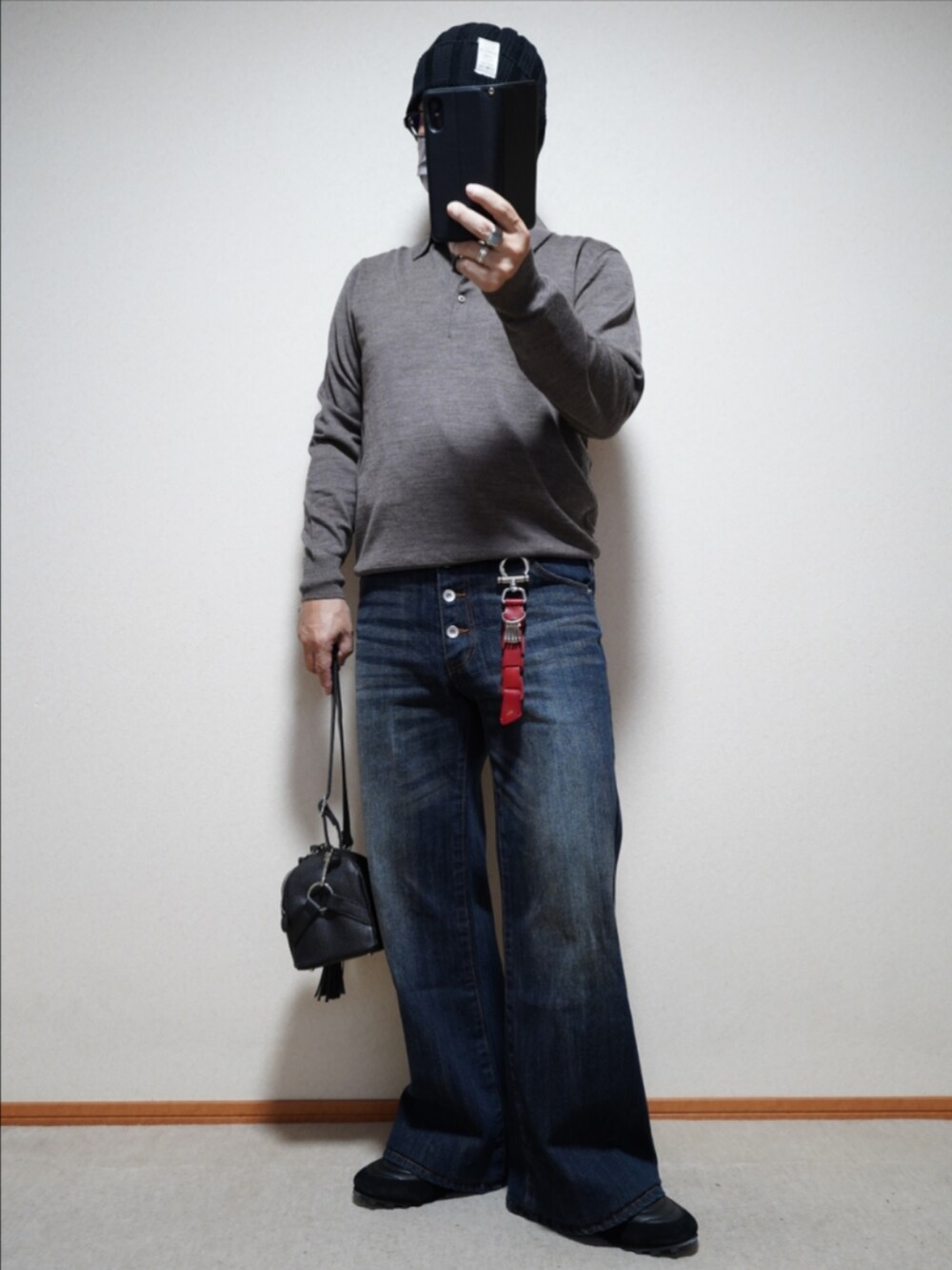 ブラック系のスニーカー、ブルー系のデニムパンツ、ブラック系のショルダーバッグを着用したメンズの秋コーディネートの2枚目の写真