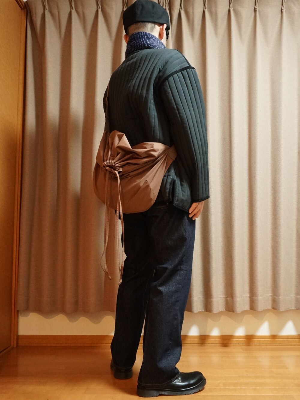 ブラック系のシューズ、ブルー系のデニムパンツ、ブラック系のミリタリージャケットを着用したメンズの秋コーディネートの4枚目の写真