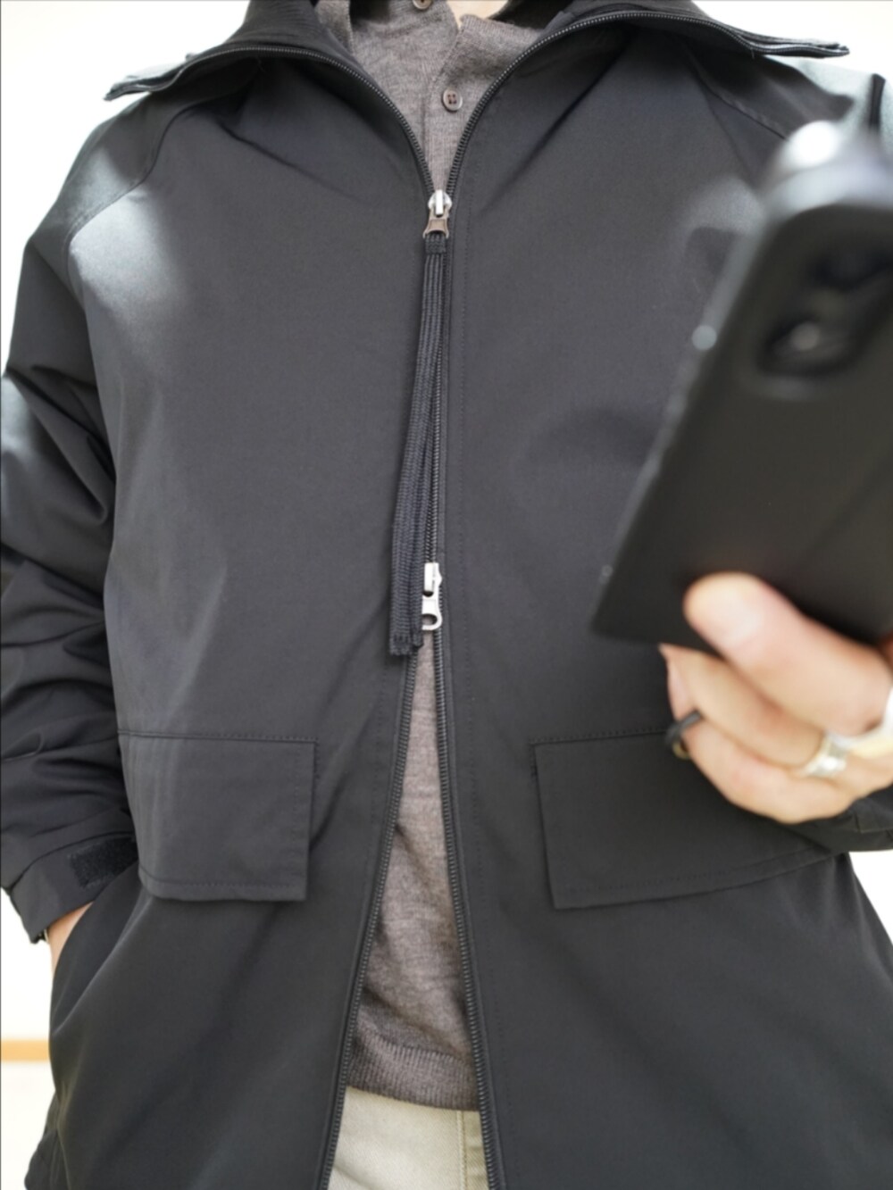 ブラック系のスニーカー、ベージュ系のデニムパンツ、ブラック系のブルゾンを着用したメンズの秋コーディネートの3枚目の写真