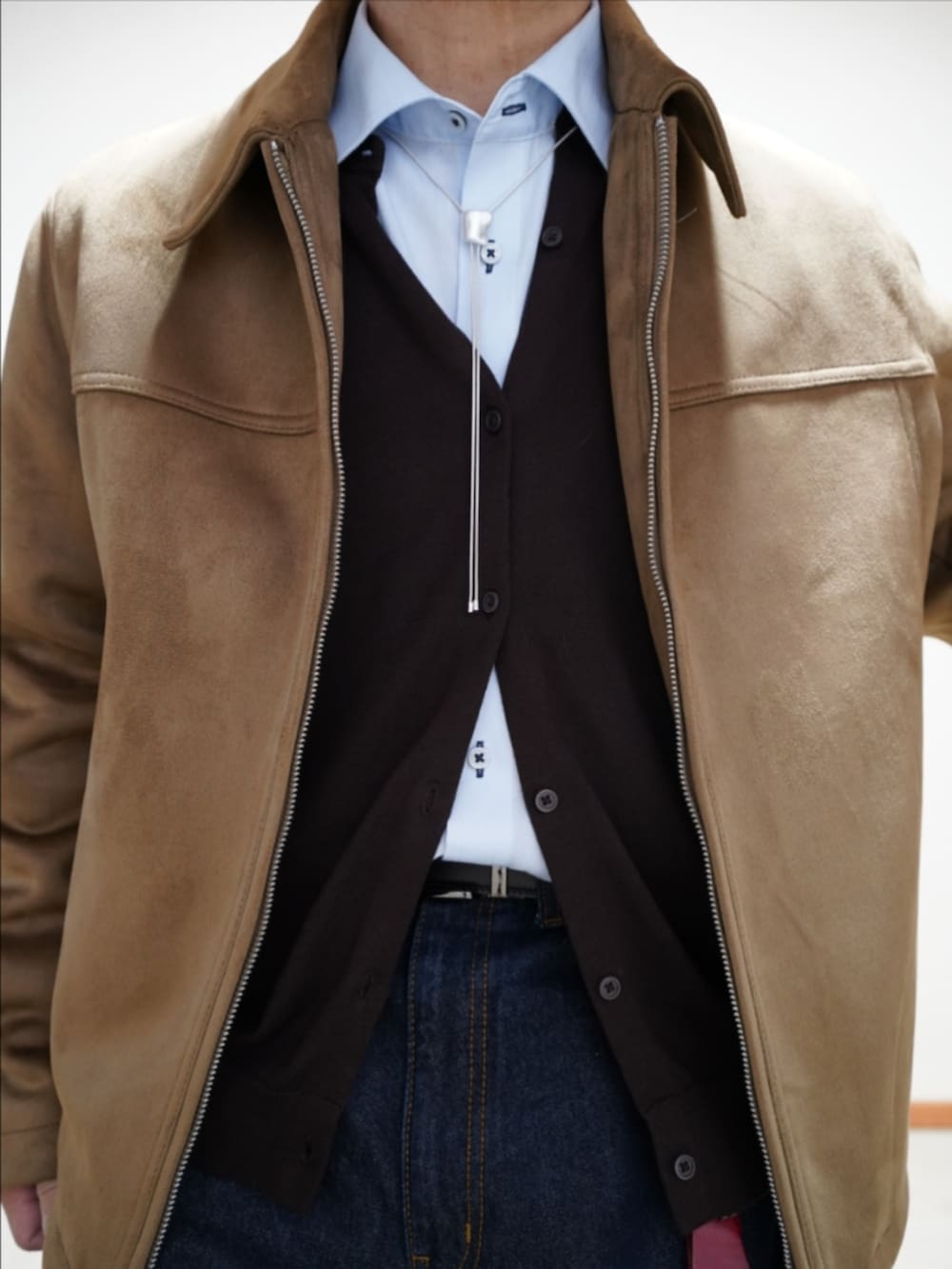 ブラック系のドレスシューズ、ブルー系のデニムパンツ、ブラウン系のカーディガン/ボレロを着用したメンズの冬コーディネートの3枚目の写真