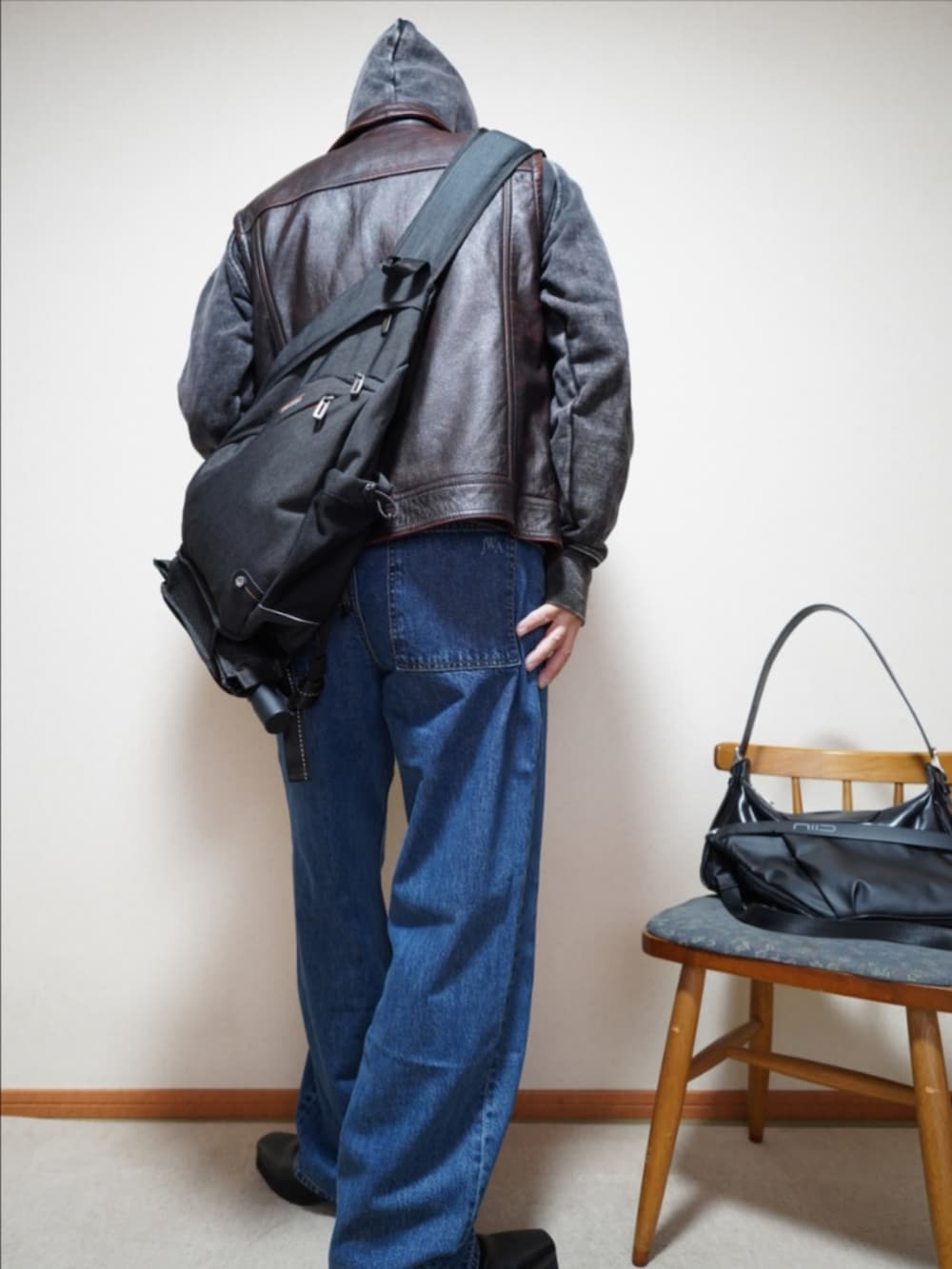 ブラック系のブーツ、ブルー系のデニムパンツ、ブラック系のパーカーを着用したメンズの春コーディネートの4枚目の写真