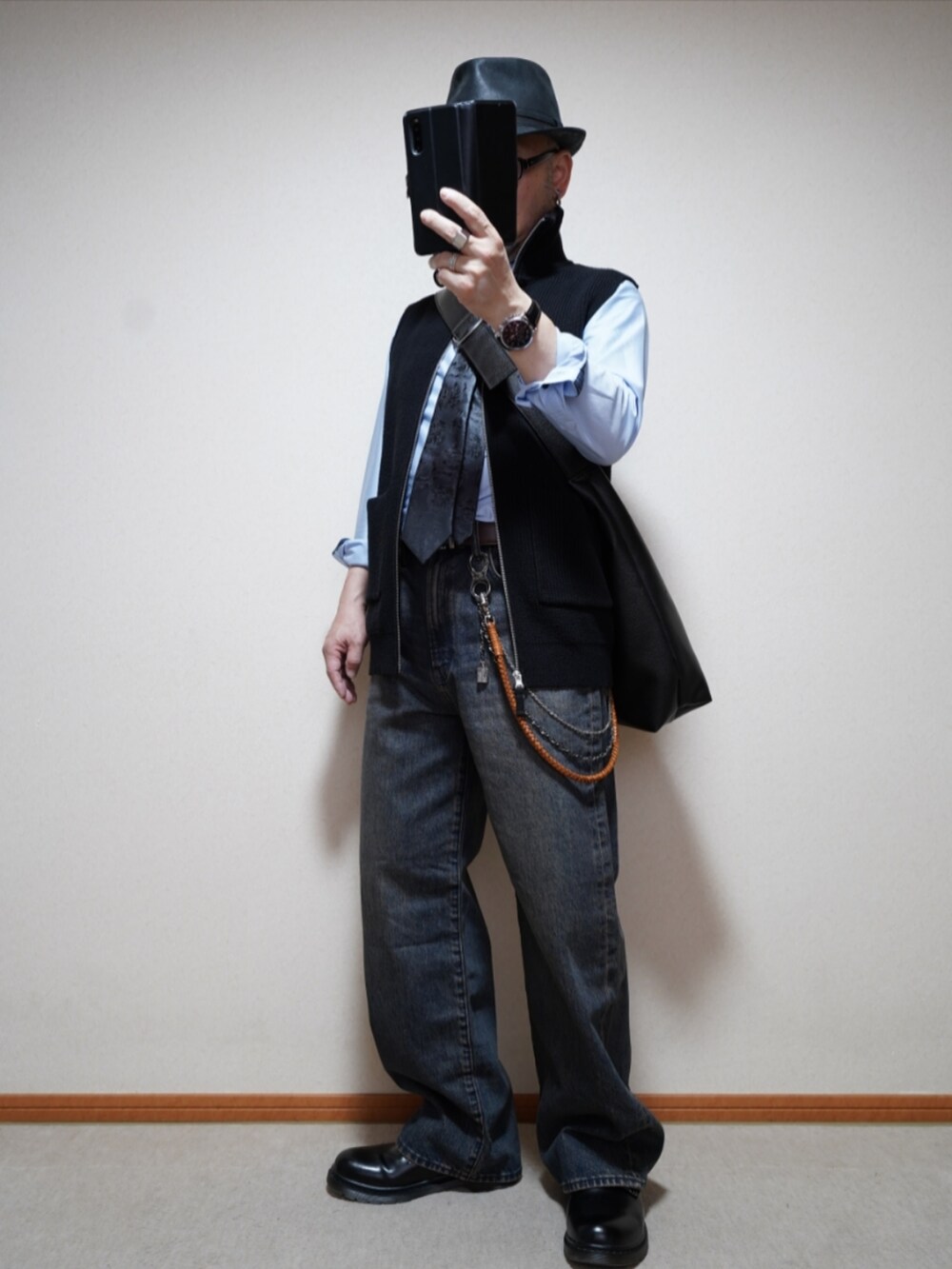 ブルー系のデニムパンツ、ブラック系のジャケット/アウター、ブラック系のネクタイを着用したメンズの春コーディネートの2枚目の写真