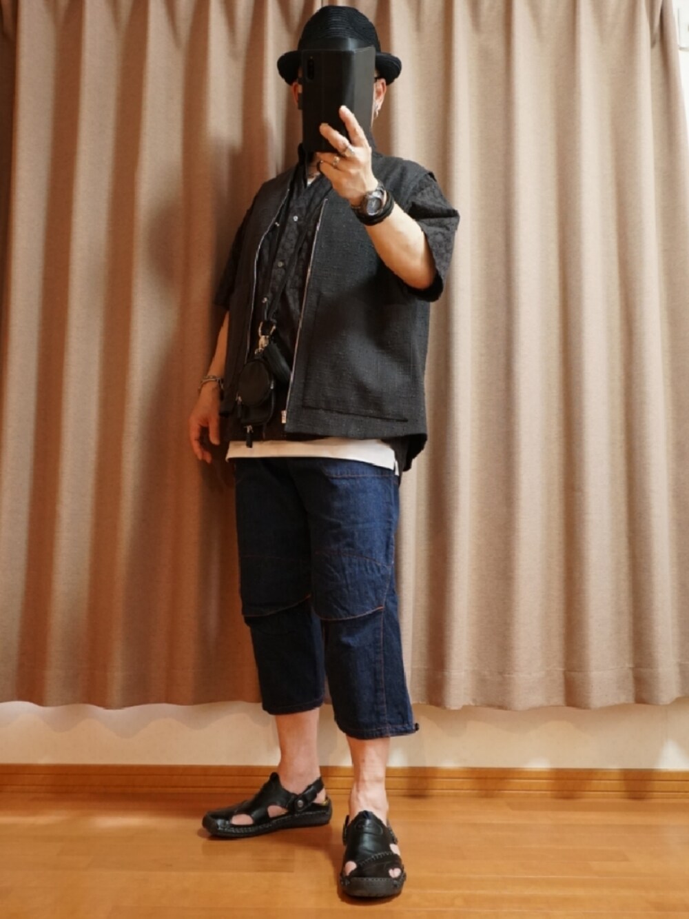 ブラック系のサンダル、ブルー系のデニムパンツ、ホワイト系のタンクトップを着用したメンズの夏コーディネートの2枚目の写真