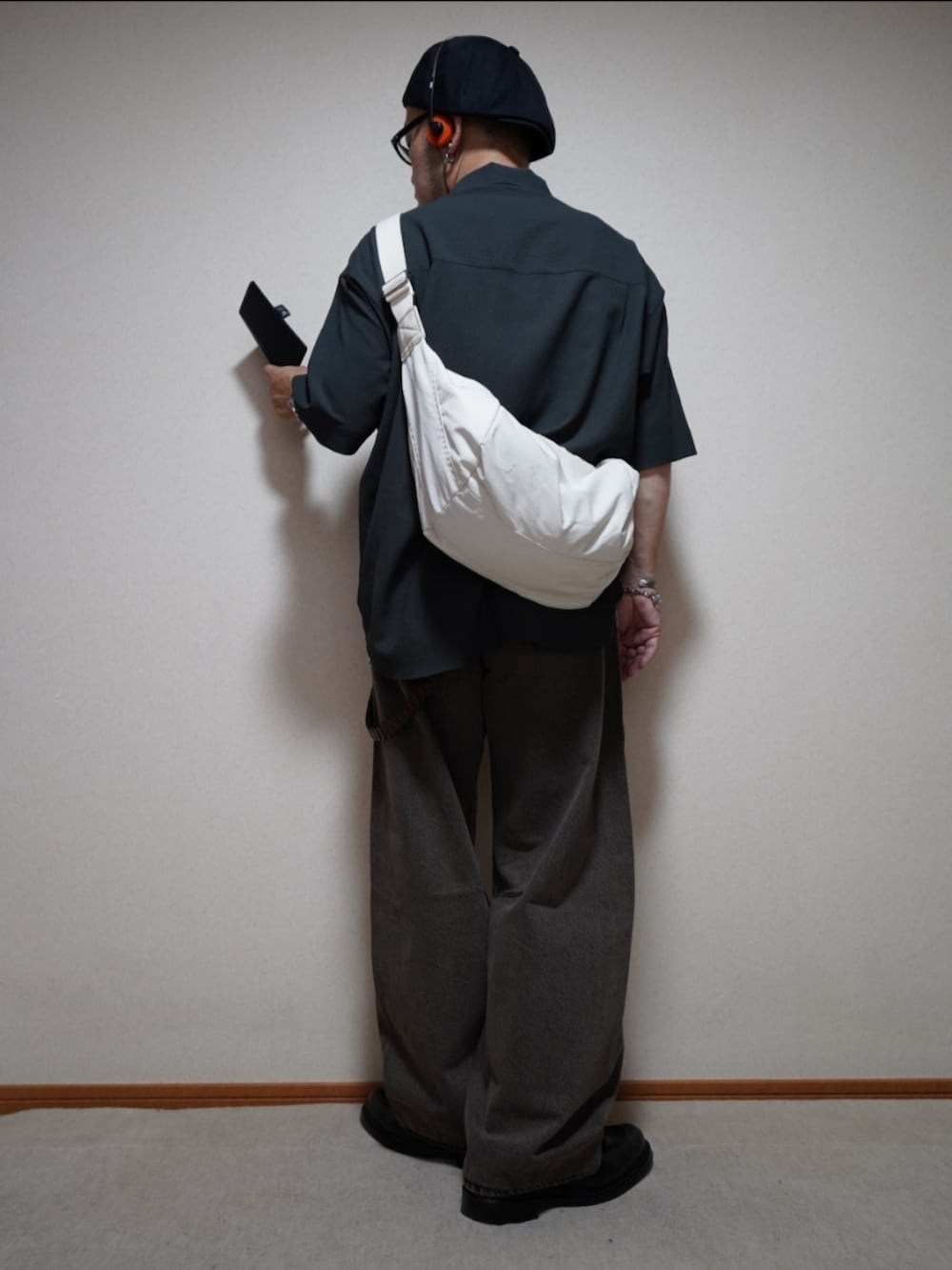 ブラック系のシューズ、ブラウン系のデニムパンツ、グレー系のタンクトップを着用したメンズの夏コーディネートの5枚目の写真