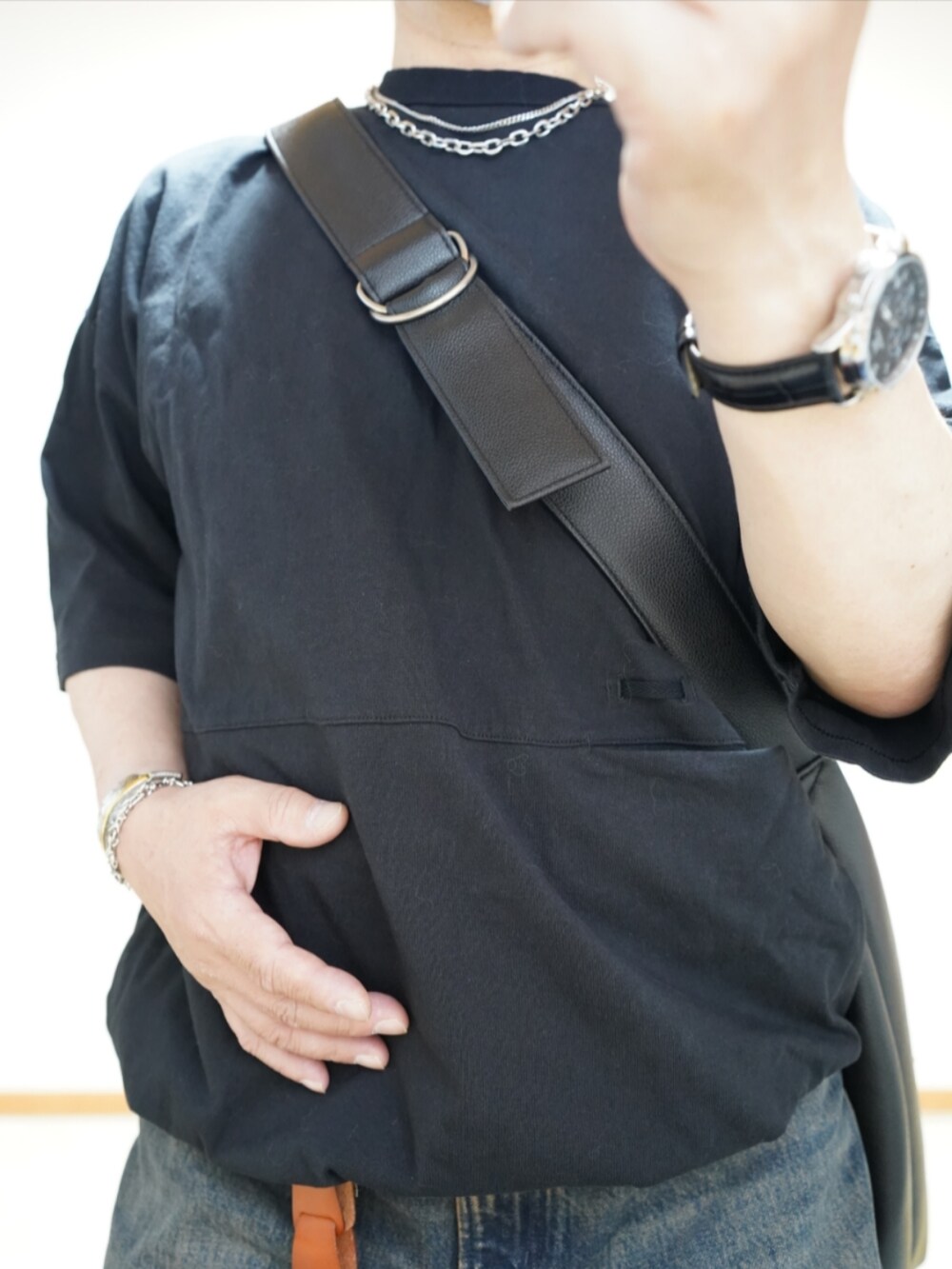 ブラック系のシューズ、ブルー系のデニムパンツ、ブラック系のTシャツ/カットソーを着用したメンズの夏コーディネートの4枚目の写真