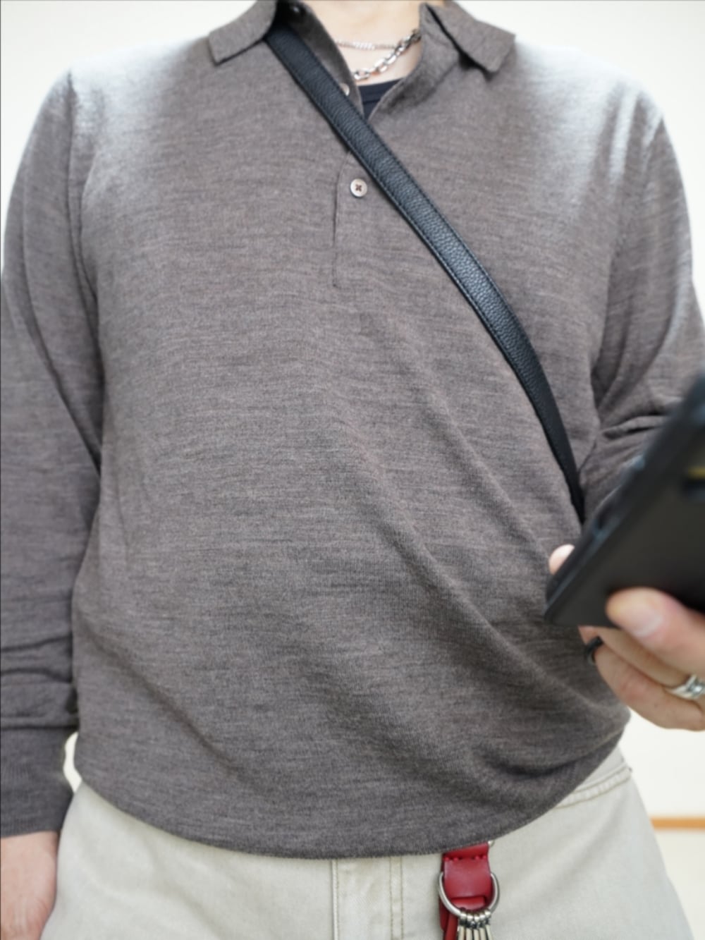 ブラック系のシューズ、ベージュ系のデニムパンツ、ブラック系のショルダーバッグを着用したメンズの秋コーディネートの3枚目の写真