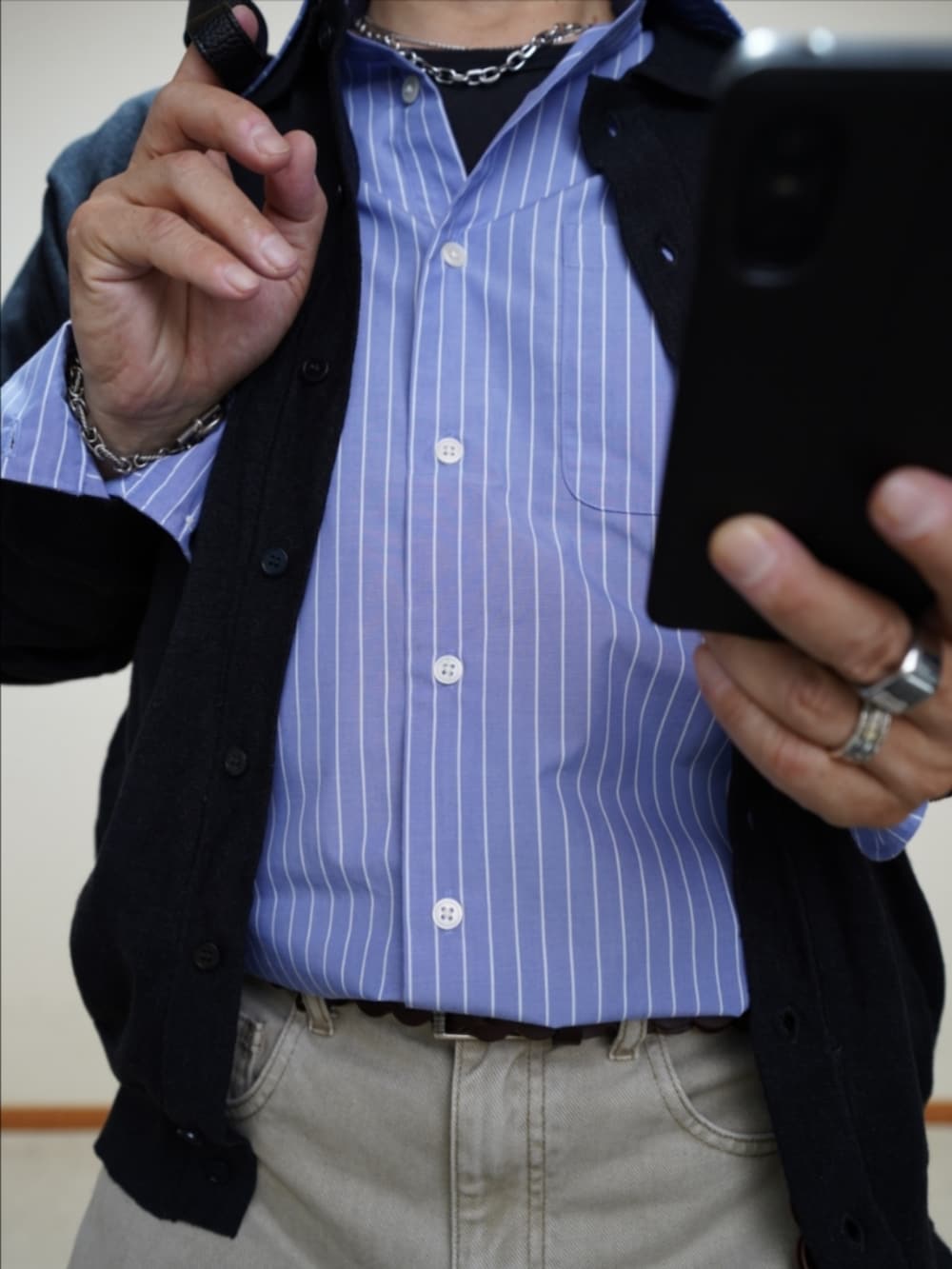 ブラック系のスリッポン、ベージュ系のデニムパンツ、ブラック系のショルダーバッグを着用したメンズの秋コーディネートの3枚目の写真