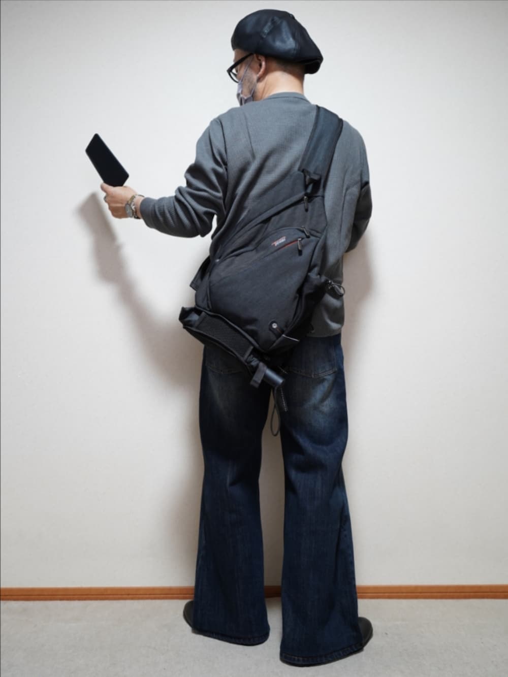 ブルー系のデニムパンツ、グレー系のTシャツ/カットソー、ブラック系のバッグを着用したメンズの秋コーディネートの4枚目の写真