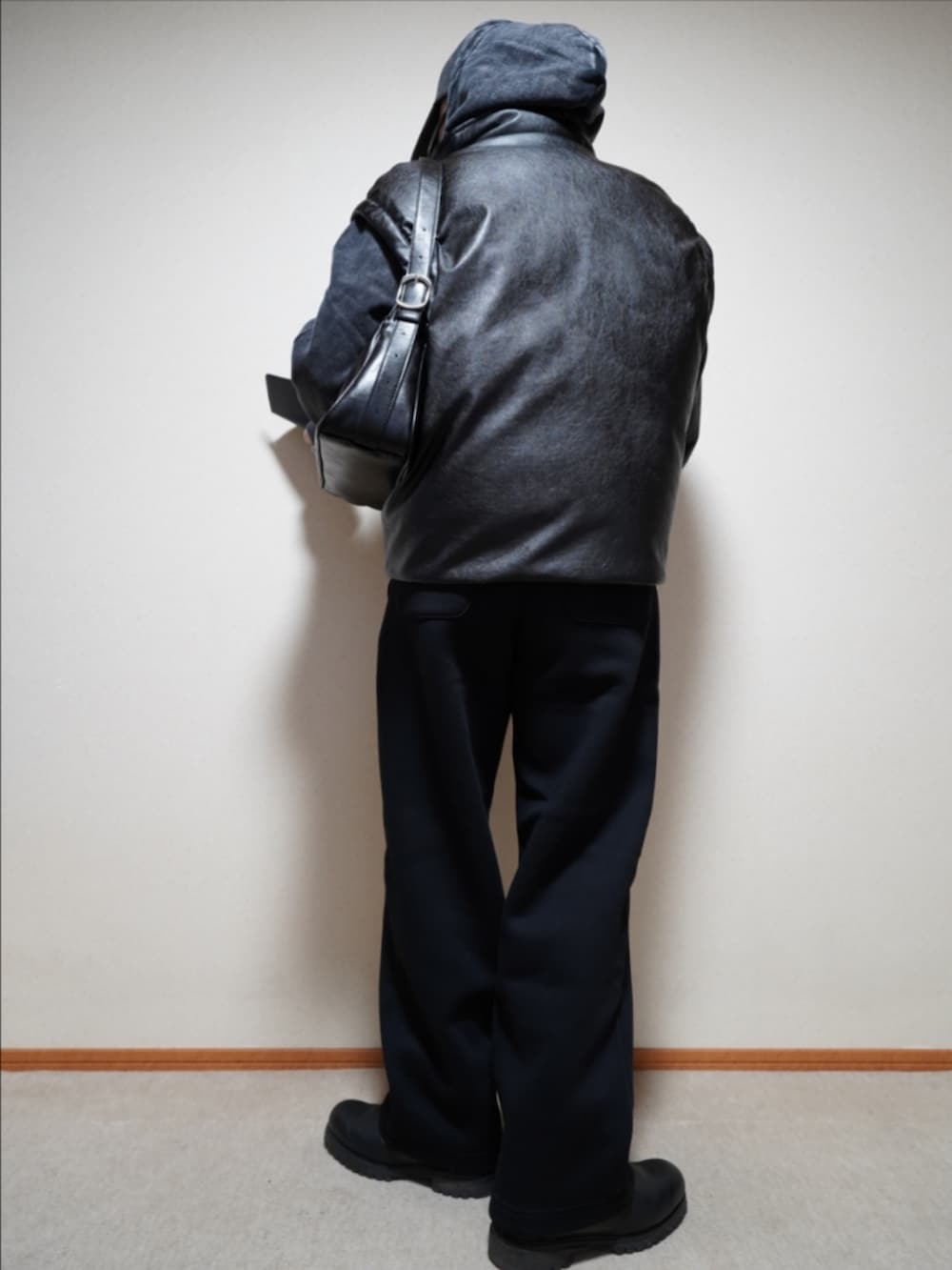 ブラック系のブーツ、ブラック系のスウェットパンツ、ブラック系のパーカーを着用したメンズの冬コーディネートの4枚目の写真