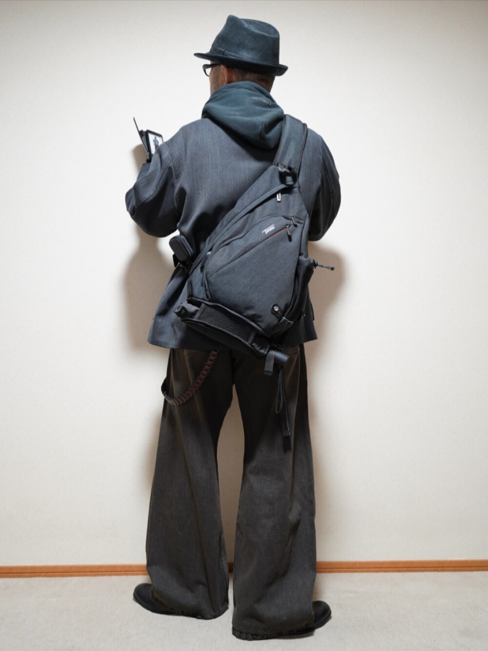 ブラック系のシューズ、ブラック系のデニムパンツ、ブラック系のパーカーを着用したメンズの春コーディネートの3枚目の写真