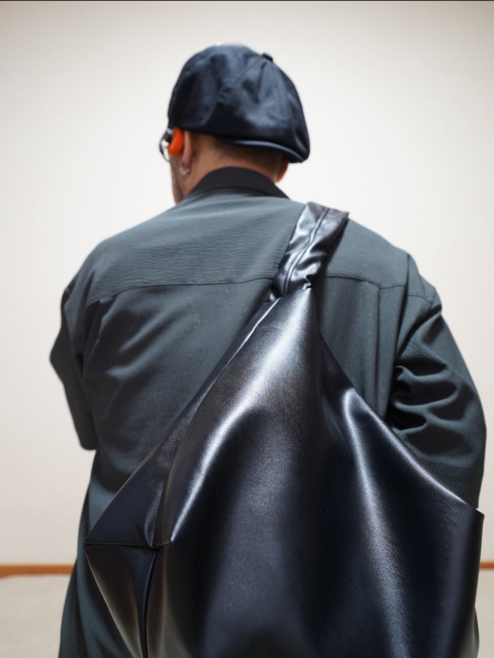 ブラック系のスニーカー、ブルー系のデニムパンツ、グレー系のタンクトップを着用したメンズの夏コーディネートの2枚目の写真