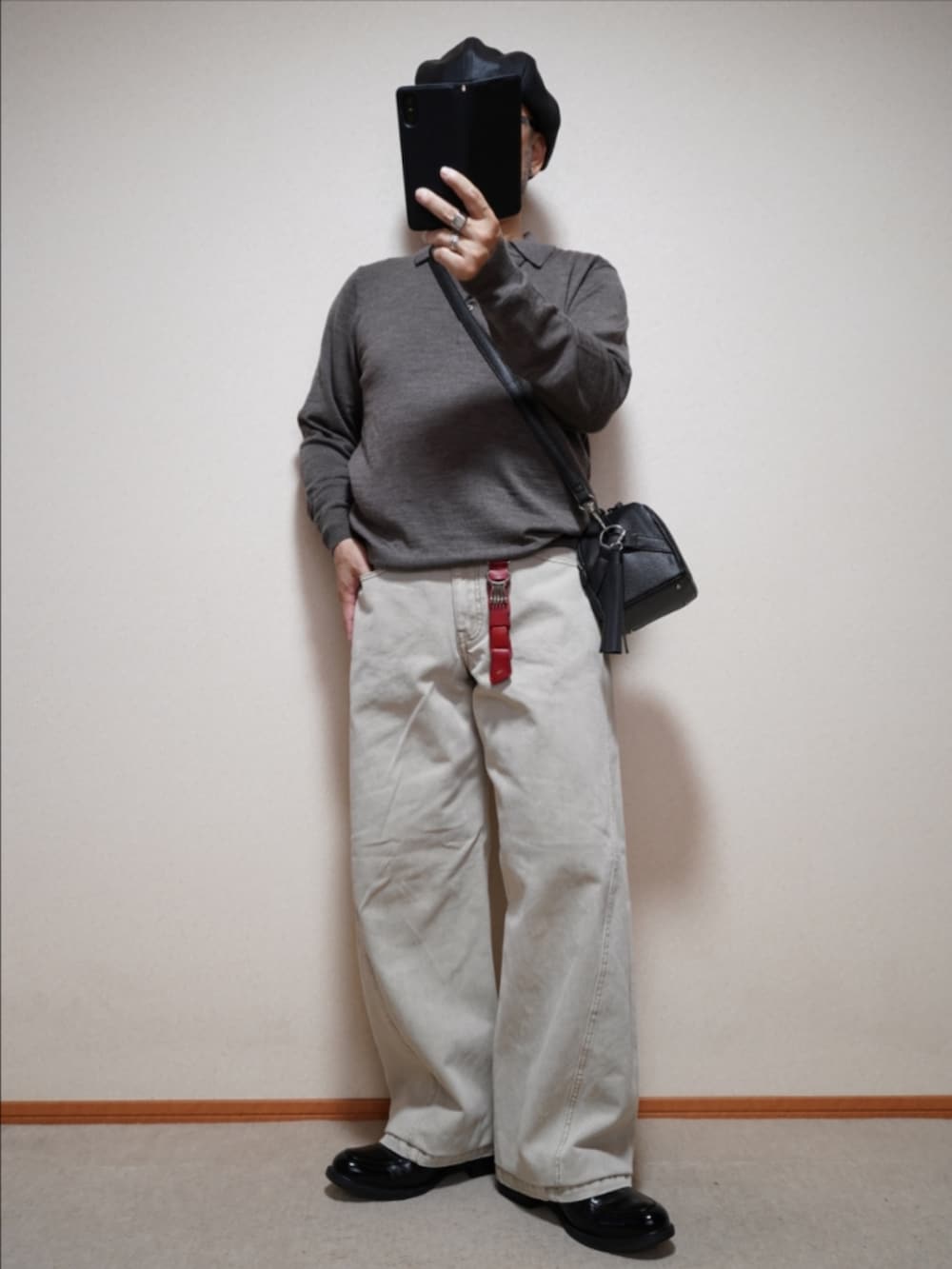 ブラック系のシューズ、ベージュ系のデニムパンツ、ブラック系のショルダーバッグを着用したメンズの秋コーディネートの2枚目の写真