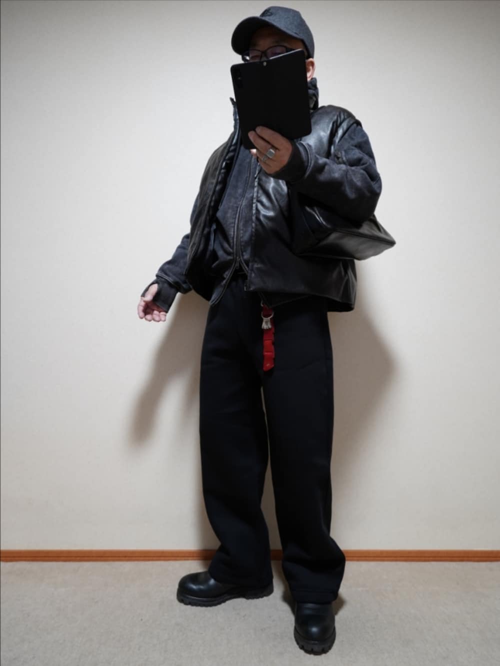 ブラック系のブーツ、ブラック系のスウェットパンツ、ブラック系のパーカーを着用したメンズの冬コーディネートの2枚目の写真