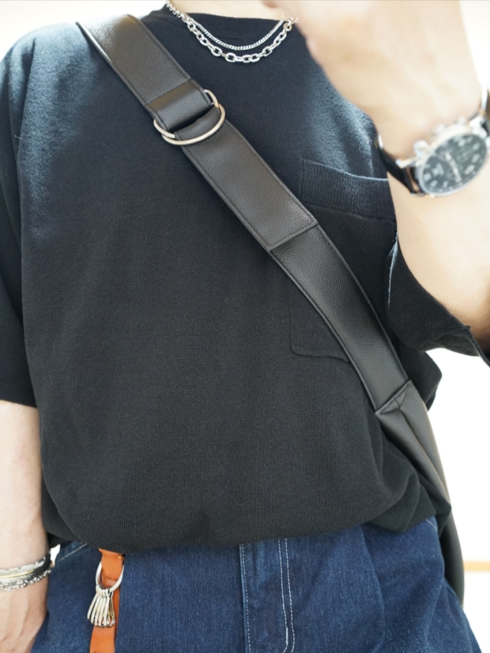 ブラック系のシューズ、ブルー系のデニムパンツ、ブラック系のTシャツ/カットソーを着用したメンズの夏コーディネートの4枚目の写真