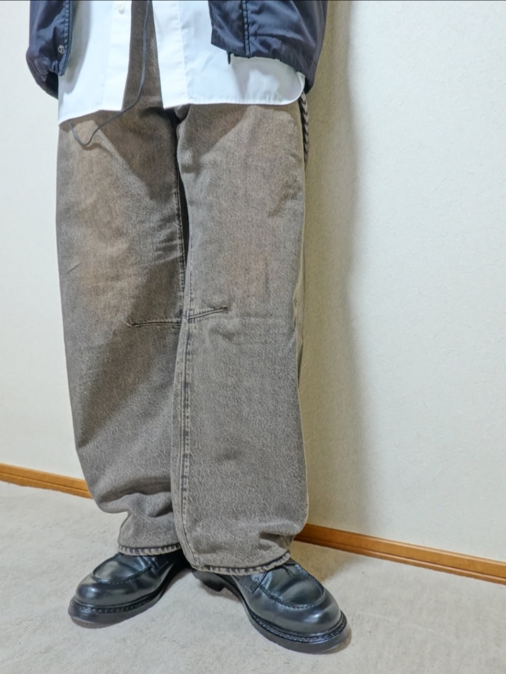 ブラック系のシューズ、ブラウン系のデニムパンツ、ブラック系のショルダーバッグを着用したメンズの秋コーディネートの4枚目の写真