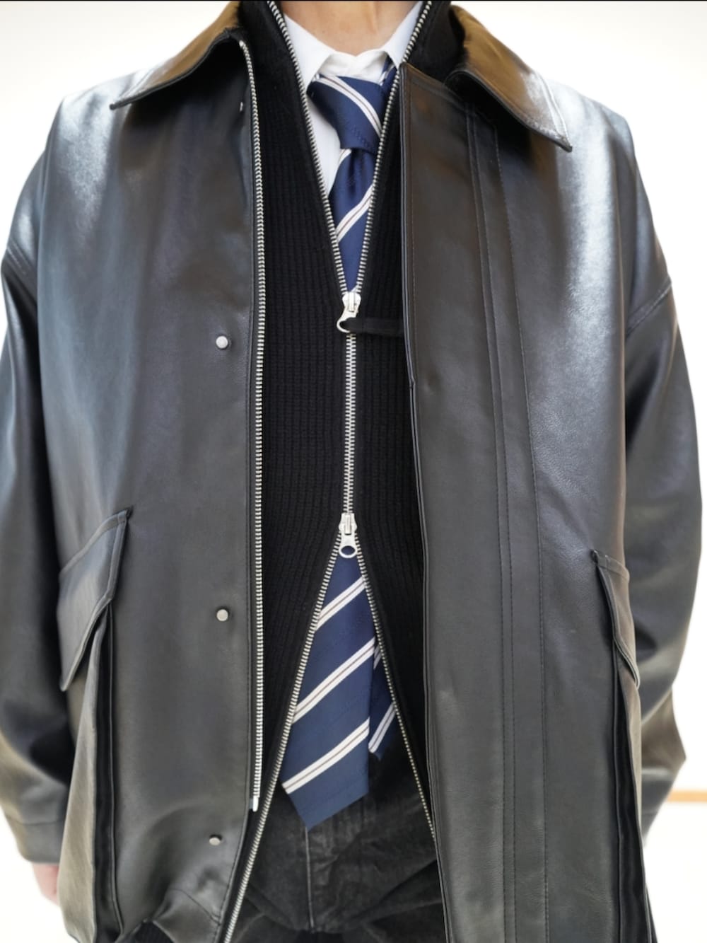 ブラック系のシューズ、ブラック系のデニムパンツ、ブラック系のジャケット/アウターを着用したメンズの冬コーディネートの3枚目の写真