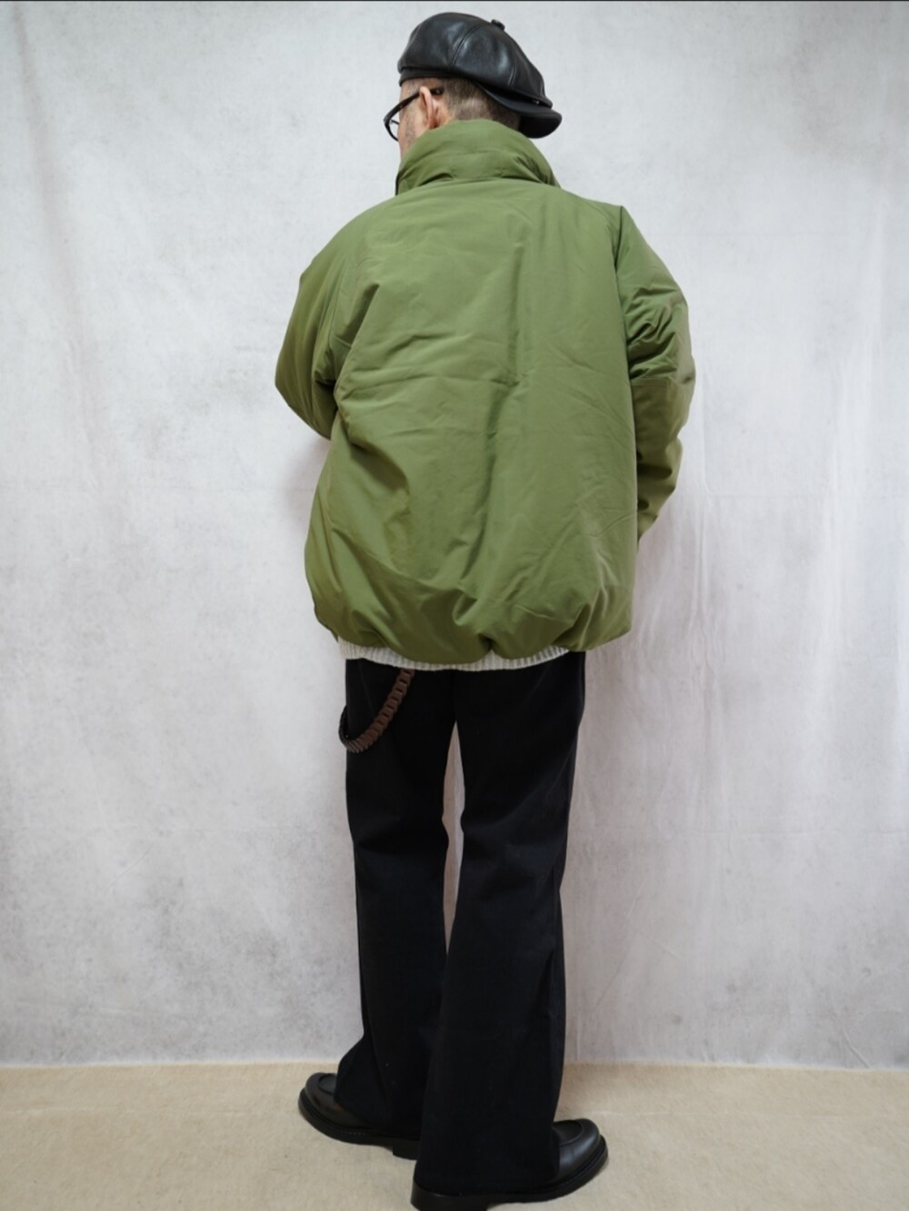 ブラック系のシューズ、グレー系のデニムパンツ、グリーン系のダウンジャケット/コートを着用したメンズの冬コーディネートの3枚目の写真