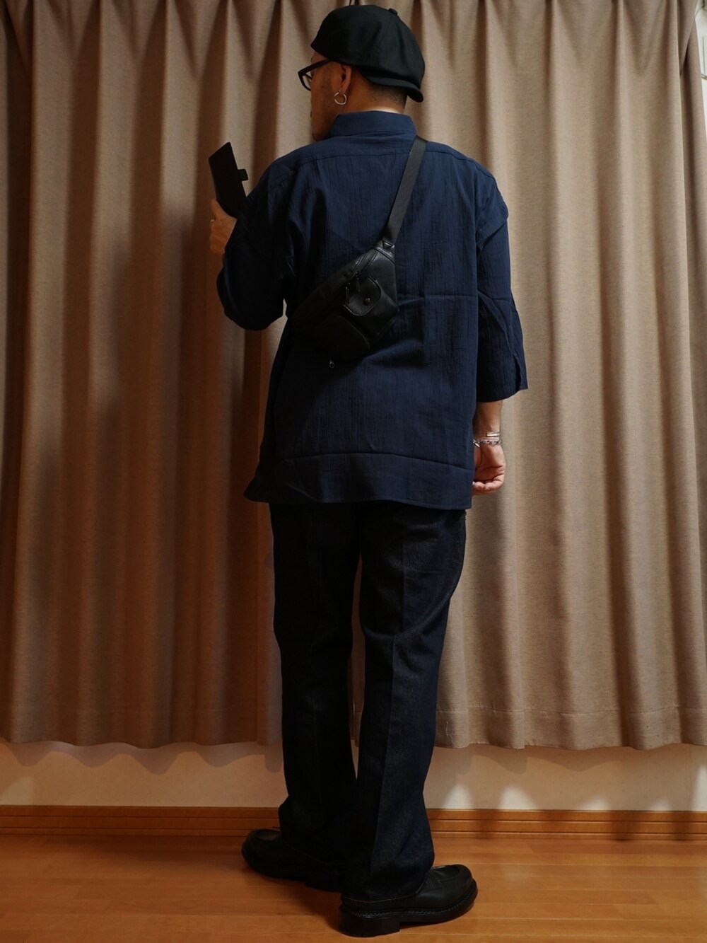 ブラック系のシューズ、ブルー系のデニムパンツ、ホワイト系のタンクトップを着用したメンズの夏コーディネートの3枚目の写真