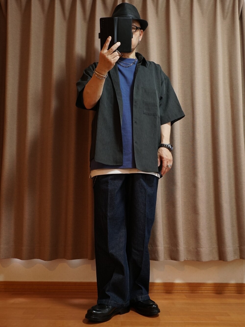 ブラック系のシューズ、ブルー系のデニムパンツ、ホワイト系のタンクトップを着用したメンズの夏コーディネートの5枚目の写真