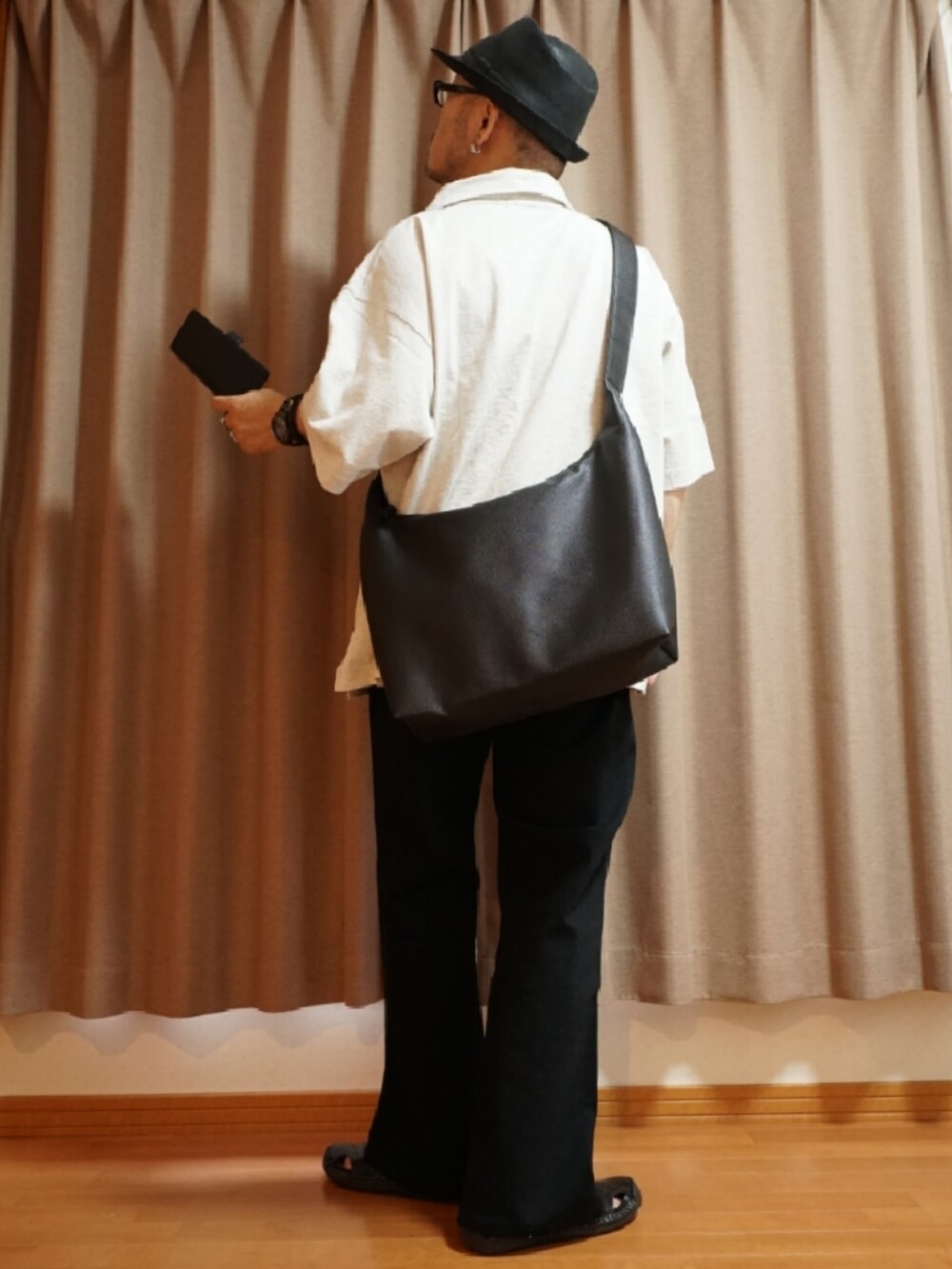 ブラック系のサンダル、グレー系のデニムパンツ、ベージュ系のTシャツ/カットソーを着用したメンズの夏コーディネートの3枚目の写真