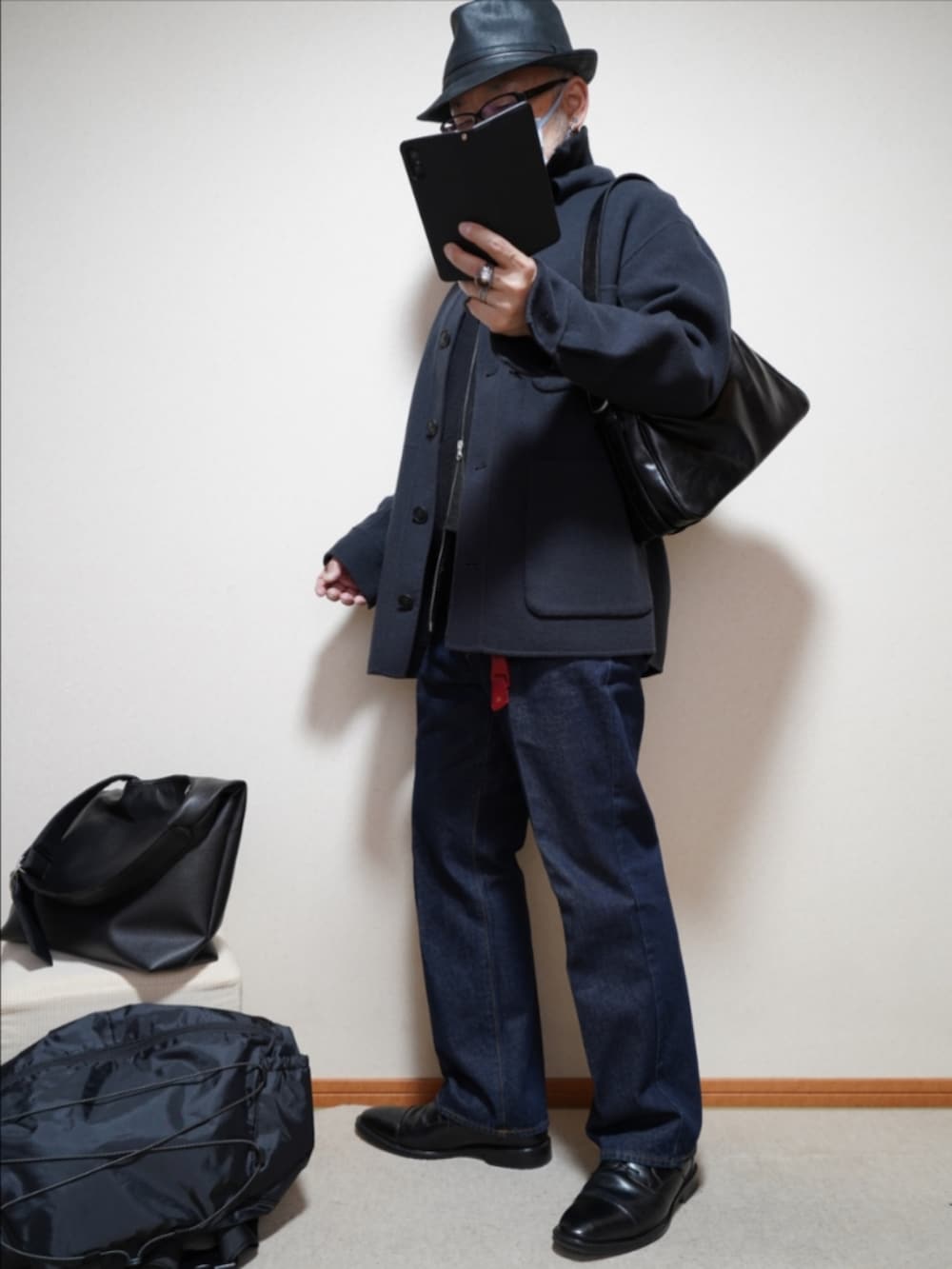 ブラック系のドレスシューズ、ブルー系のデニムパンツ、ブラック系のTシャツ/カットソーを着用したメンズの春コーディネートの2枚目の写真