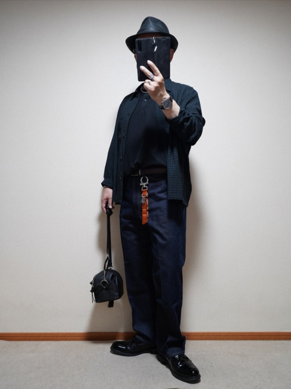 ブラック系のシューズ、ブルー系のデニムパンツ、ブラック系のショルダーバッグを着用したメンズの夏コーディネートの2枚目の写真