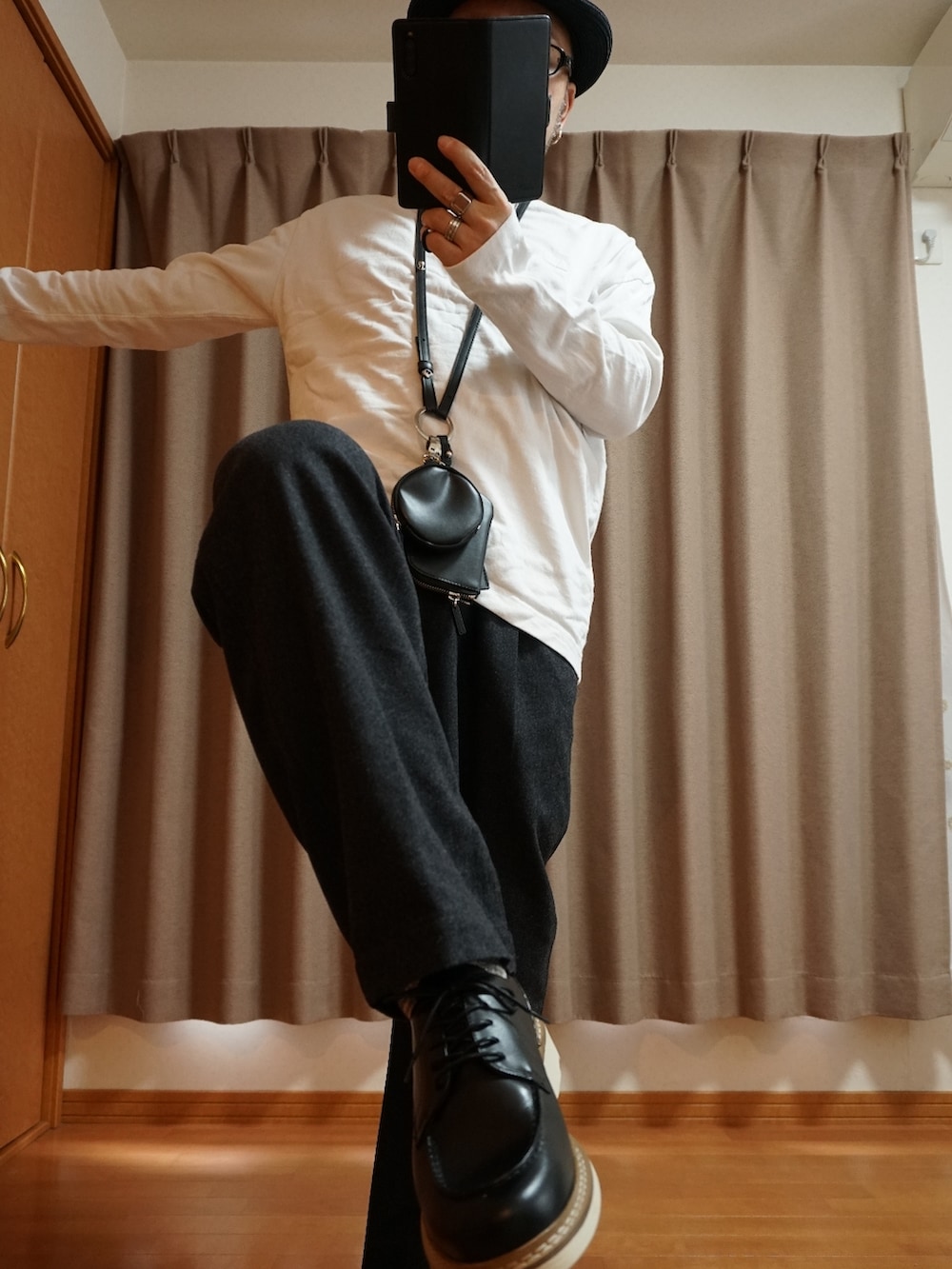 ブラック系のシューズ、グレー系のパンツ、ブラック系のショルダーバッグを着用したメンズの春コーディネートの2枚目の写真