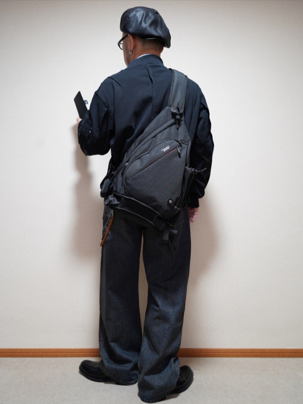 ブラック系のシューズ、ブルー系のデニムパンツ、ブラック系のMA-1を着用したメンズの春コーディネートの3枚目の写真