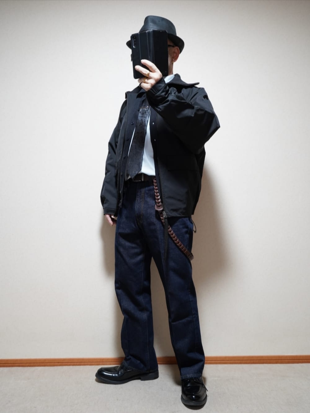 ブラック系のシューズ、ブルー系のデニムパンツ、ブラック系のネクタイを着用したメンズの春コーディネートの2枚目の写真