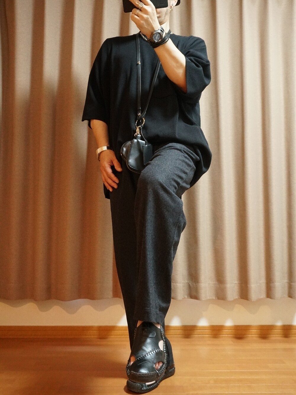 グレー系のパンツ、ブラック系のショルダーバッグ、ブラック系のニット/セーターを着用したメンズの夏コーディネートの2枚目の写真