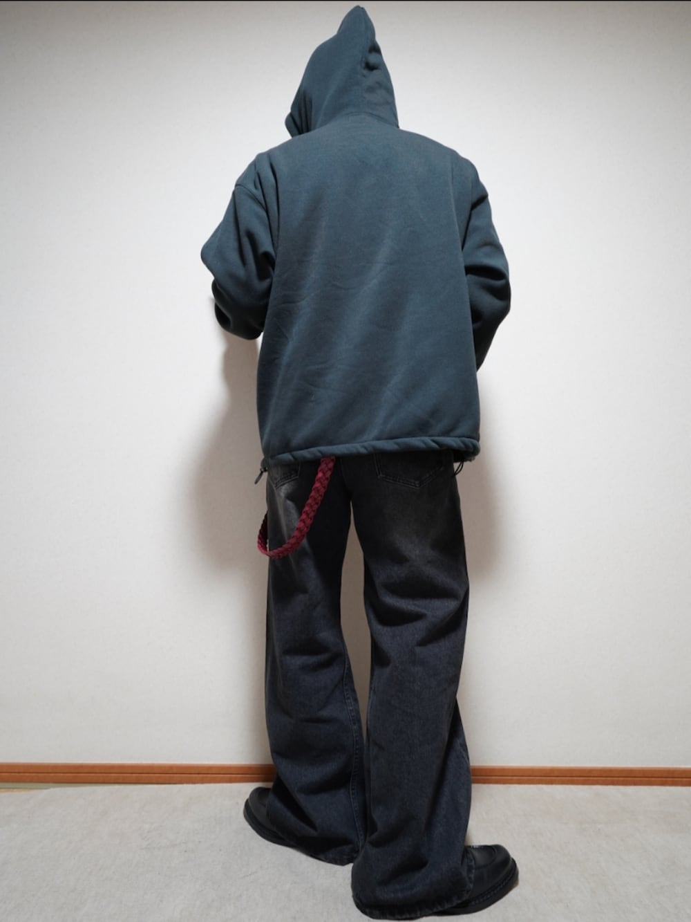 ブラック系のシューズ、ブラック系のデニムパンツ、ブラック系のパーカーを着用したメンズの春コーディネートの2枚目の写真