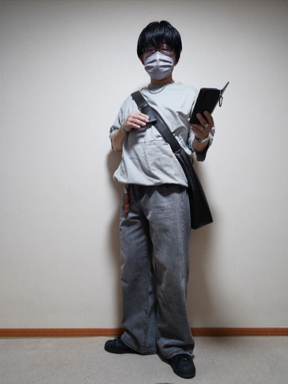 ブラック系のスニーカー、グレー系のデニムパンツ、グレー系のTシャツ/カットソーを着用したメンズの夏コーディネートの2枚目の写真