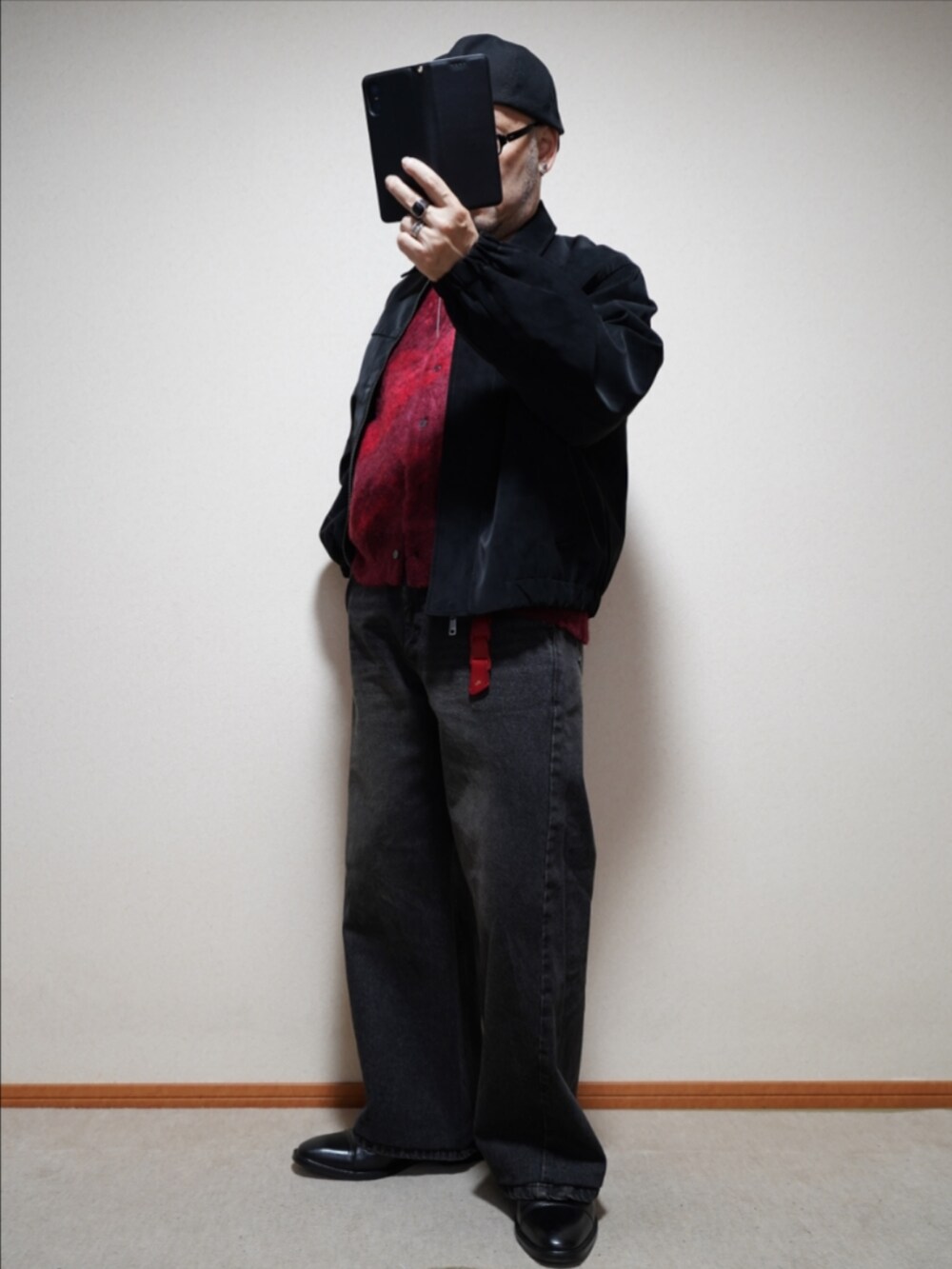 ブラック系のドレスシューズ、ブラック系のデニムパンツ、レッド系のカーディガン/ボレロを着用したメンズの冬コーディネートの2枚目の写真