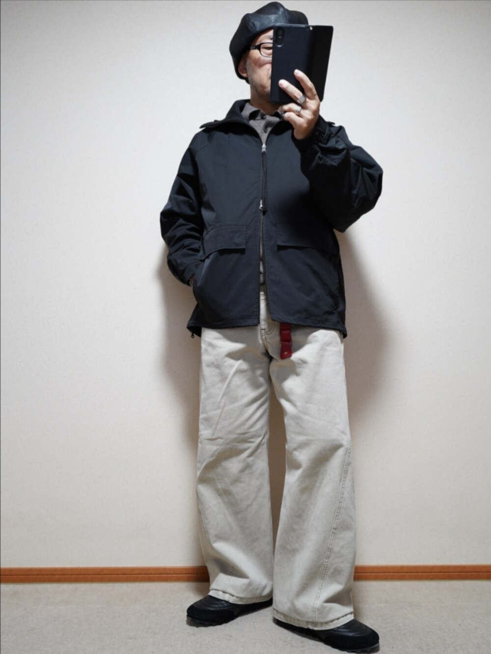 ブラック系のスニーカー、ベージュ系のデニムパンツ、ブラック系のブルゾンを着用したメンズの秋コーディネートの2枚目の写真