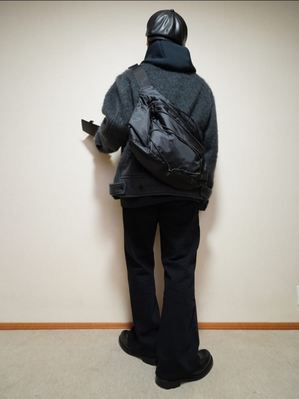 ブラック系のシューズ、グレー系のデニムパンツ、ブラック系のパーカーを着用したメンズの冬コーディネートの3枚目の写真