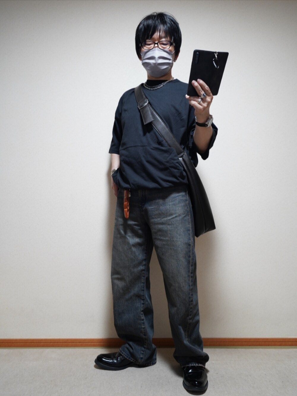 ブラック系のシューズ、ブルー系のデニムパンツ、ブラック系のTシャツ/カットソーを着用したメンズの夏コーディネートの2枚目の写真