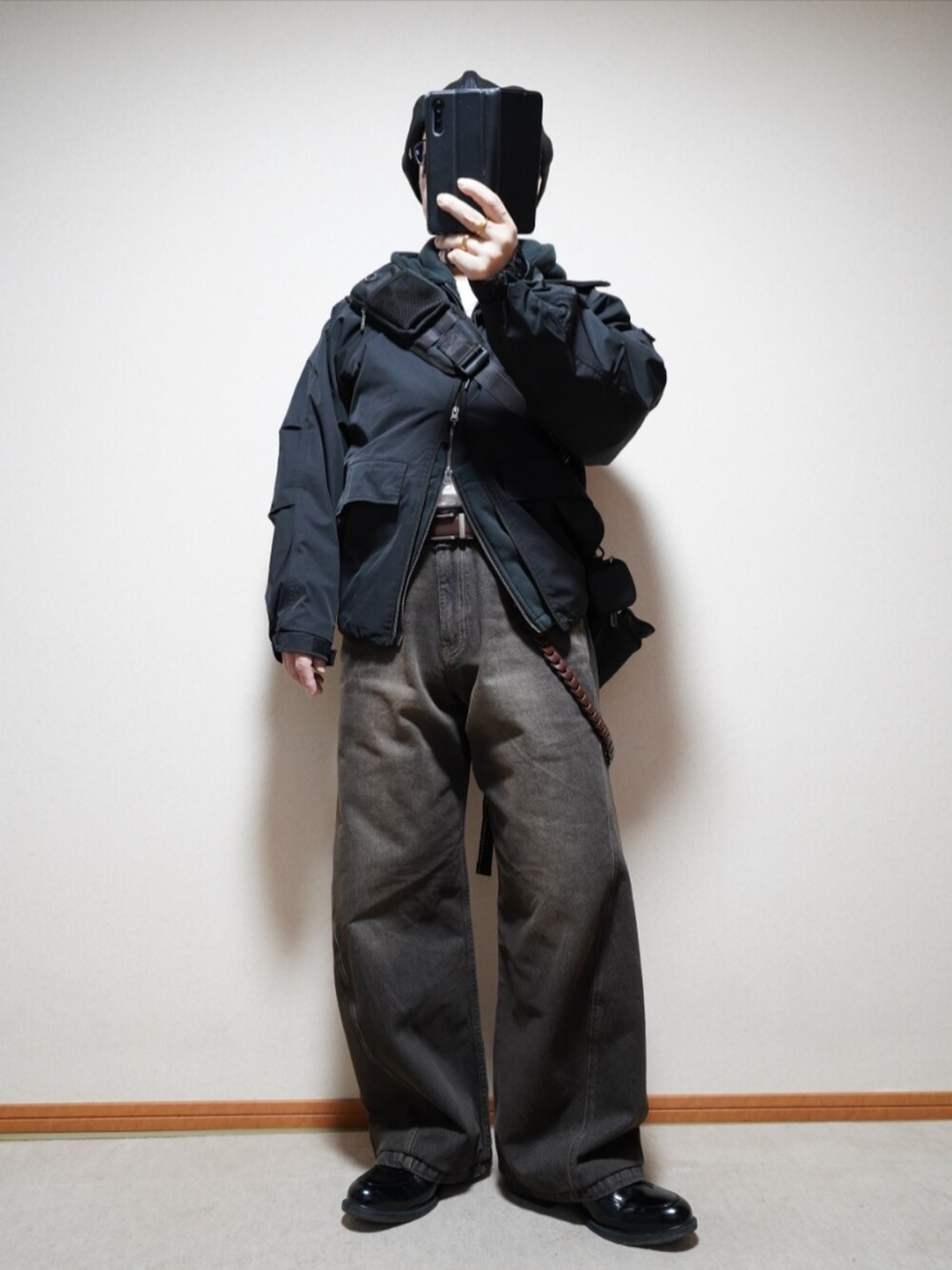 ブラック系のシューズ、ブラック系のデニムパンツ、ブラック系のパーカーを着用したメンズの春コーディネートの2枚目の写真