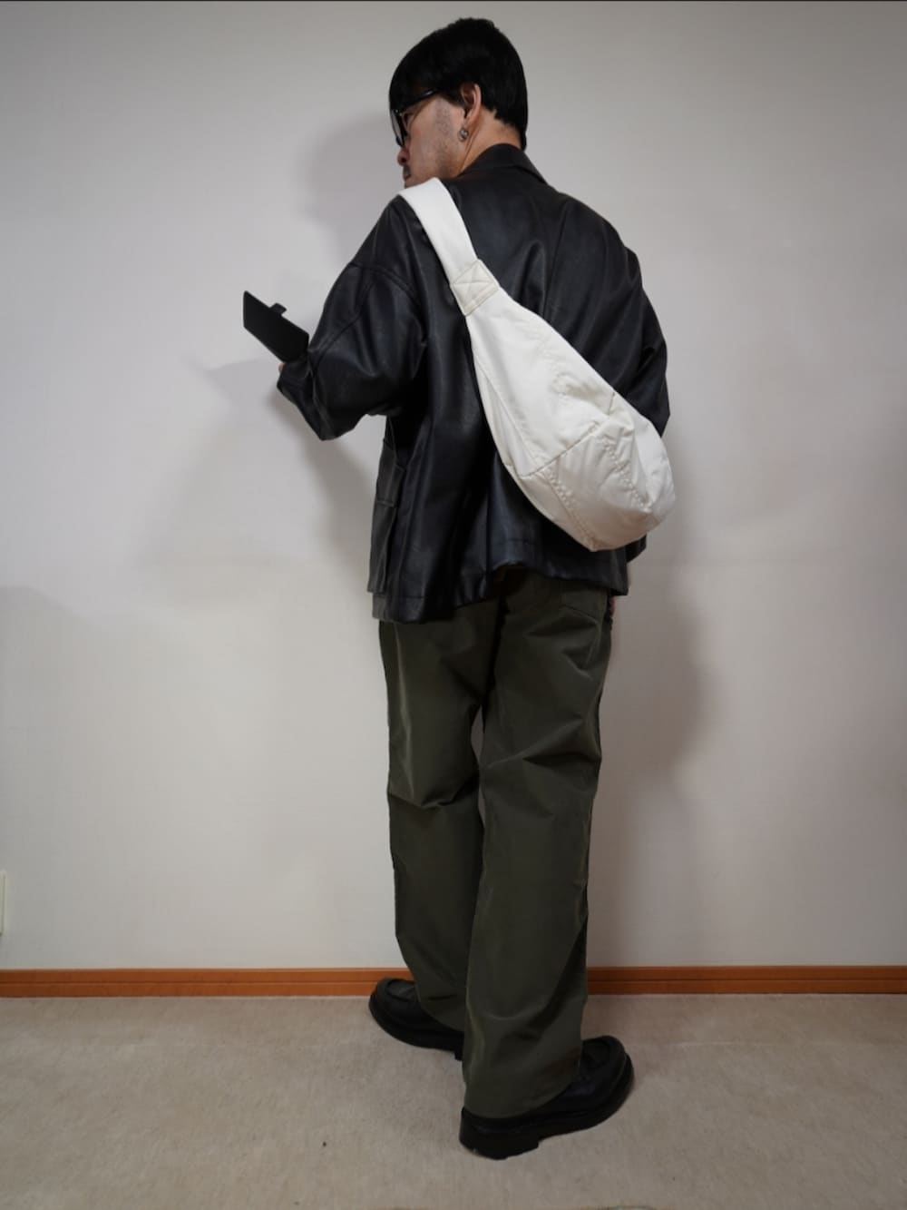 ブラック系のシューズ、グリーン系のパンツ、グレー系のニット/セーターを着用したメンズの秋コーディネートの3枚目の写真