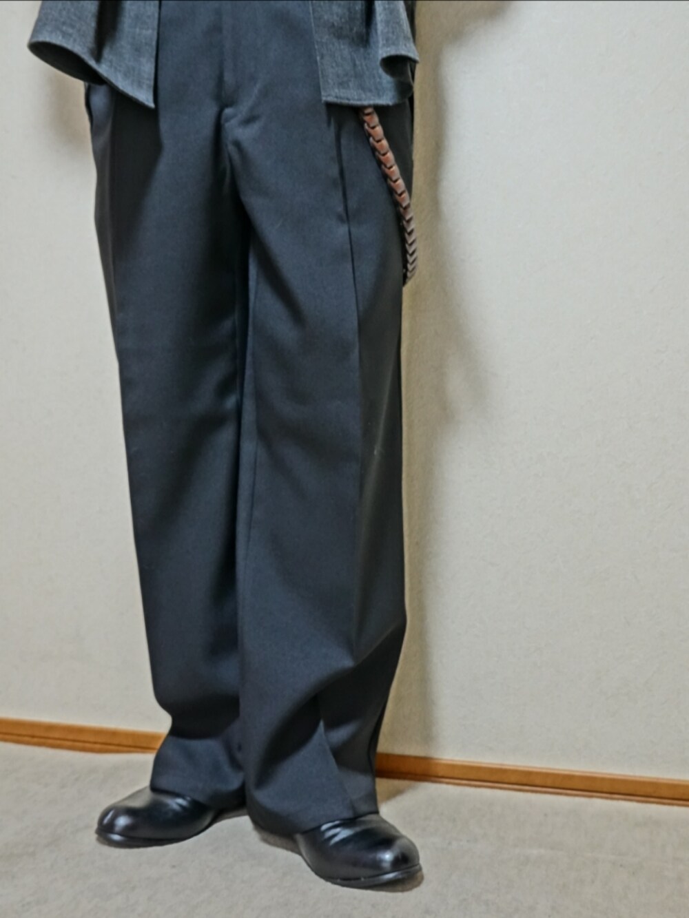 ブラック系のスリッポン、ブラック系のパンツ、ブラック系のショルダーバッグを着用したメンズの秋コーディネートの4枚目の写真