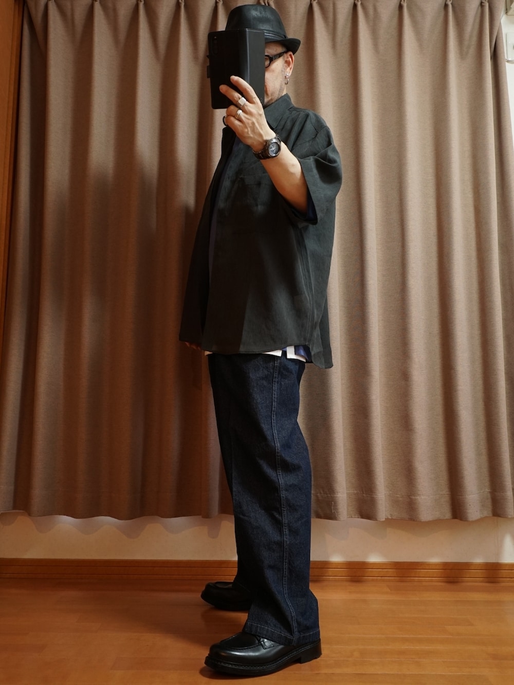 ブラック系のシューズ、ブルー系のデニムパンツ、ホワイト系のタンクトップを着用したメンズの夏コーディネートの2枚目の写真