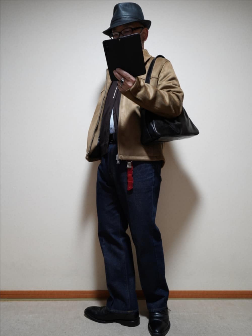 ブラック系のドレスシューズ、ブルー系のデニムパンツ、ブラウン系のカーディガン/ボレロを着用したメンズの冬コーディネートの2枚目の写真