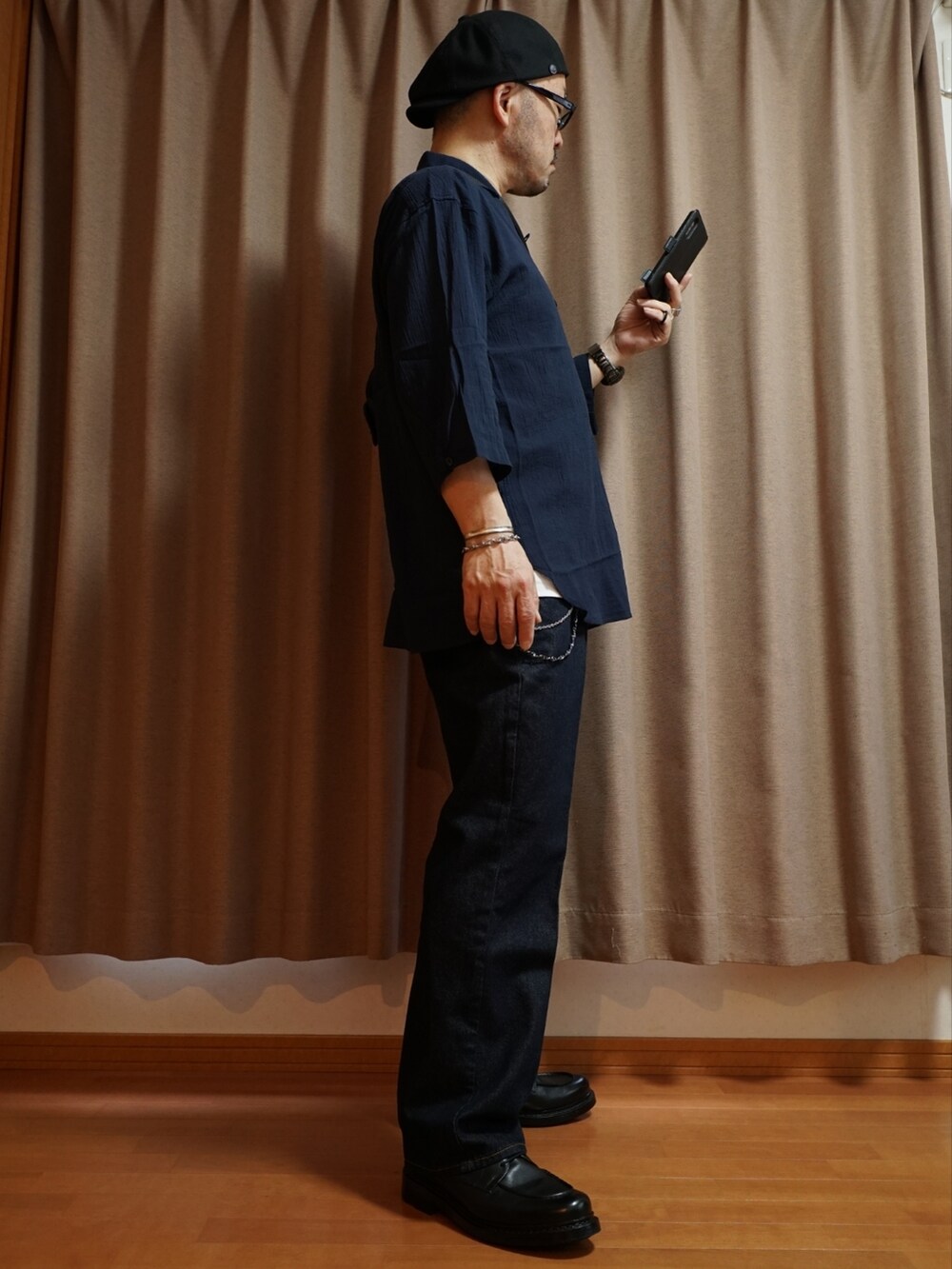 ブラック系のシューズ、ブルー系のデニムパンツ、ホワイト系のタンクトップを着用したメンズの夏コーディネートの4枚目の写真