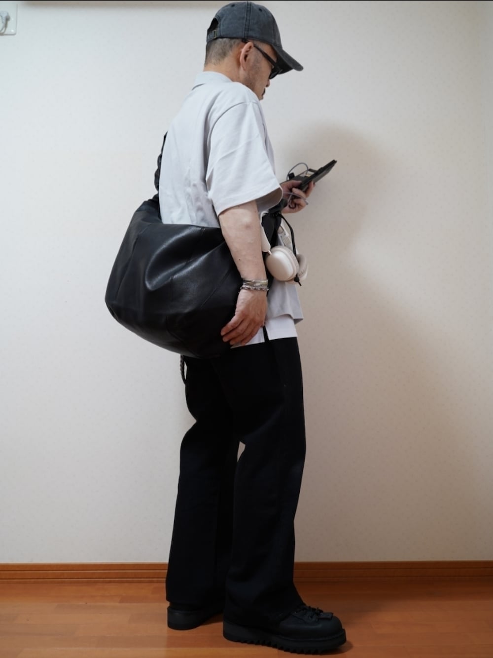 ブラック系のシューズ、グレー系のデニムパンツ、ブラック系のショルダーバッグを着用したメンズの夏コーディネートの3枚目の写真