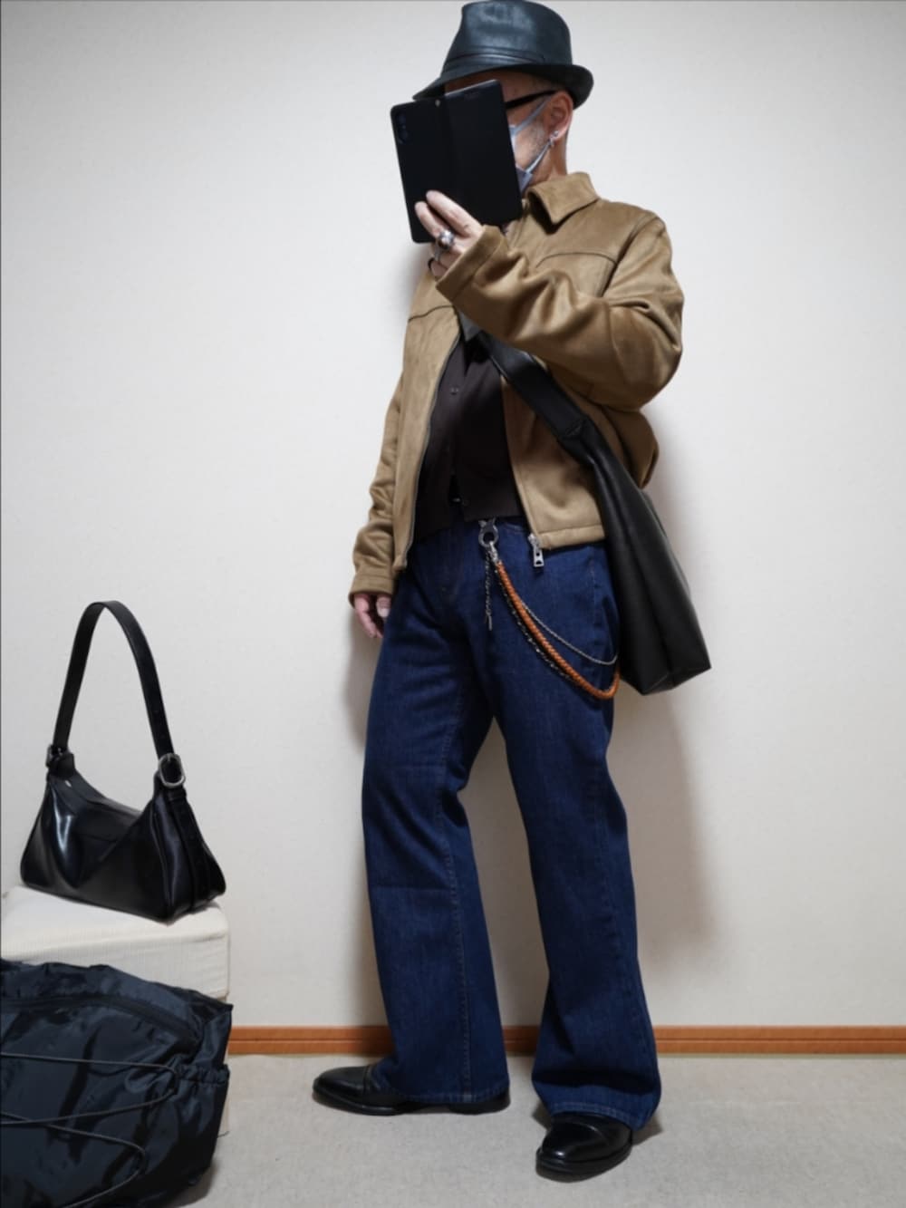 ブラック系のドレスシューズ、ブルー系のデニムパンツ、ブラウン系のカーディガン/ボレロを着用したメンズの春コーディネートの2枚目の写真