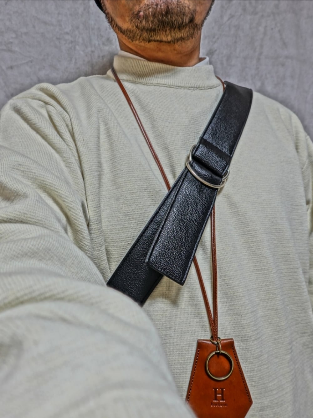 ブラック系のシューズ、ホワイト系のニット/セーター、ブルー系のデニムパンツを着用したメンズの春コーディネートの5枚目の写真