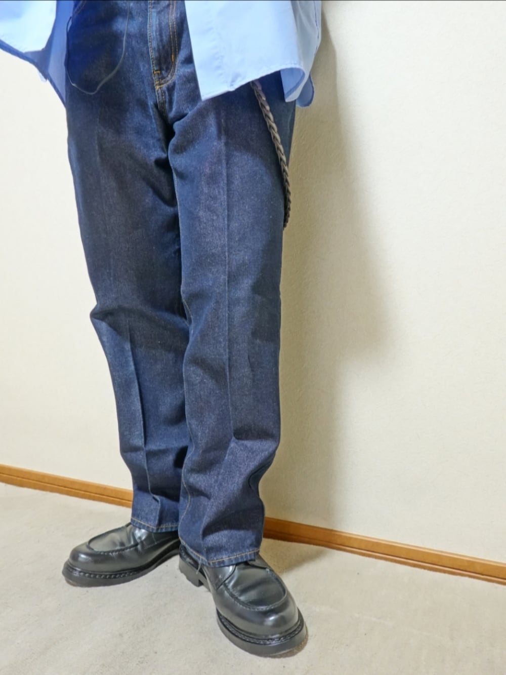 ブラック系のシューズ、ブルー系のデニムパンツ、グレー系のタンクトップを着用したメンズの夏コーディネートの4枚目の写真