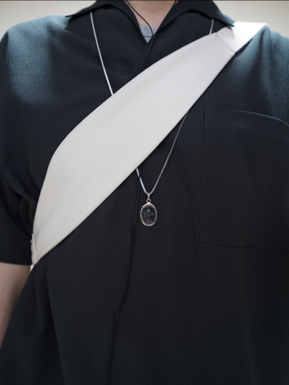 ブラック系のシューズ、ブラウン系のデニムパンツ、グレー系のタンクトップを着用したメンズの夏コーディネートの2枚目の写真