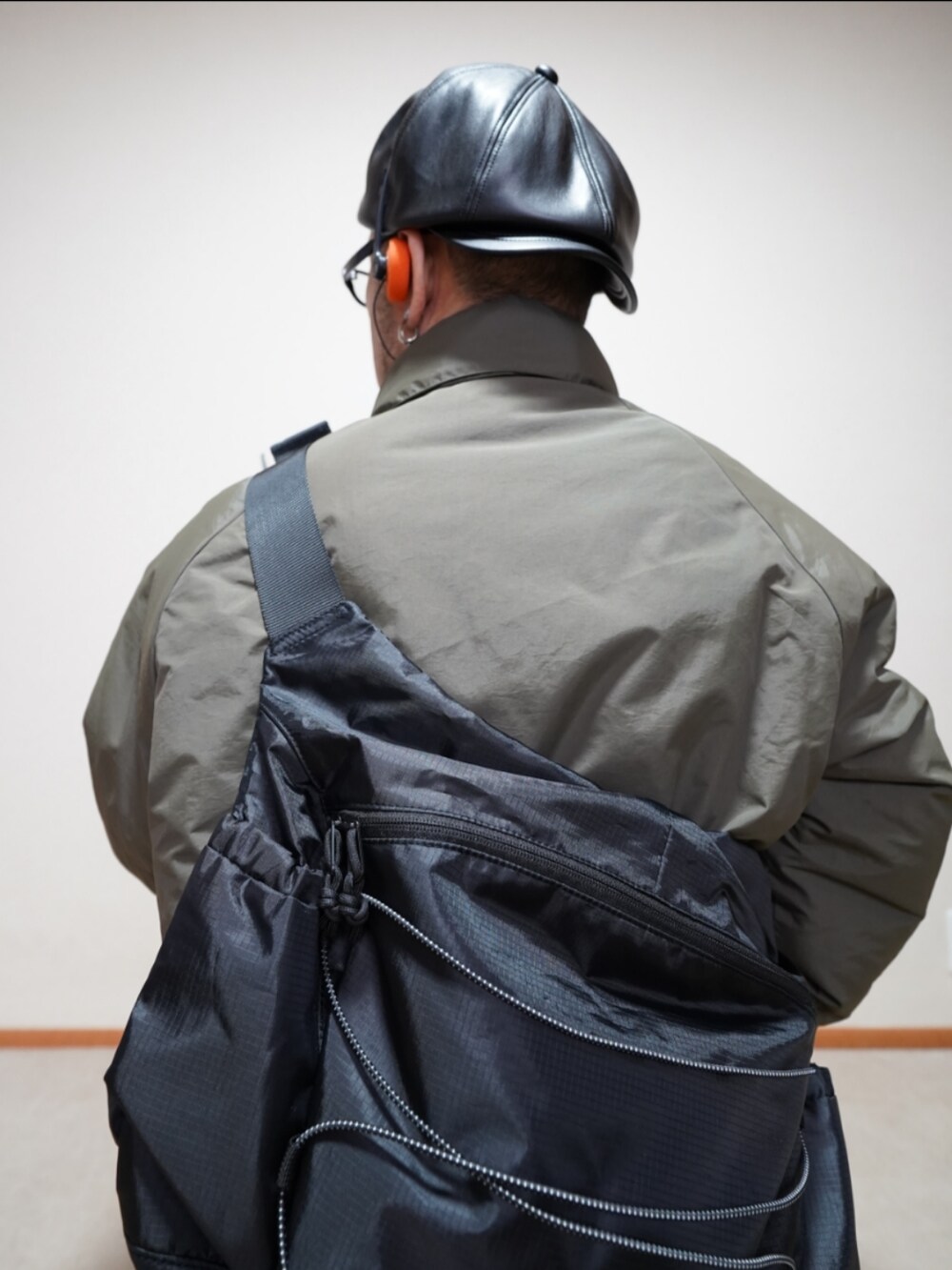 ホワイト系のスニーカー、ブルー系のデニムパンツ、グリーン系のミリタリージャケットを着用したメンズの冬コーディネートの5枚目の写真